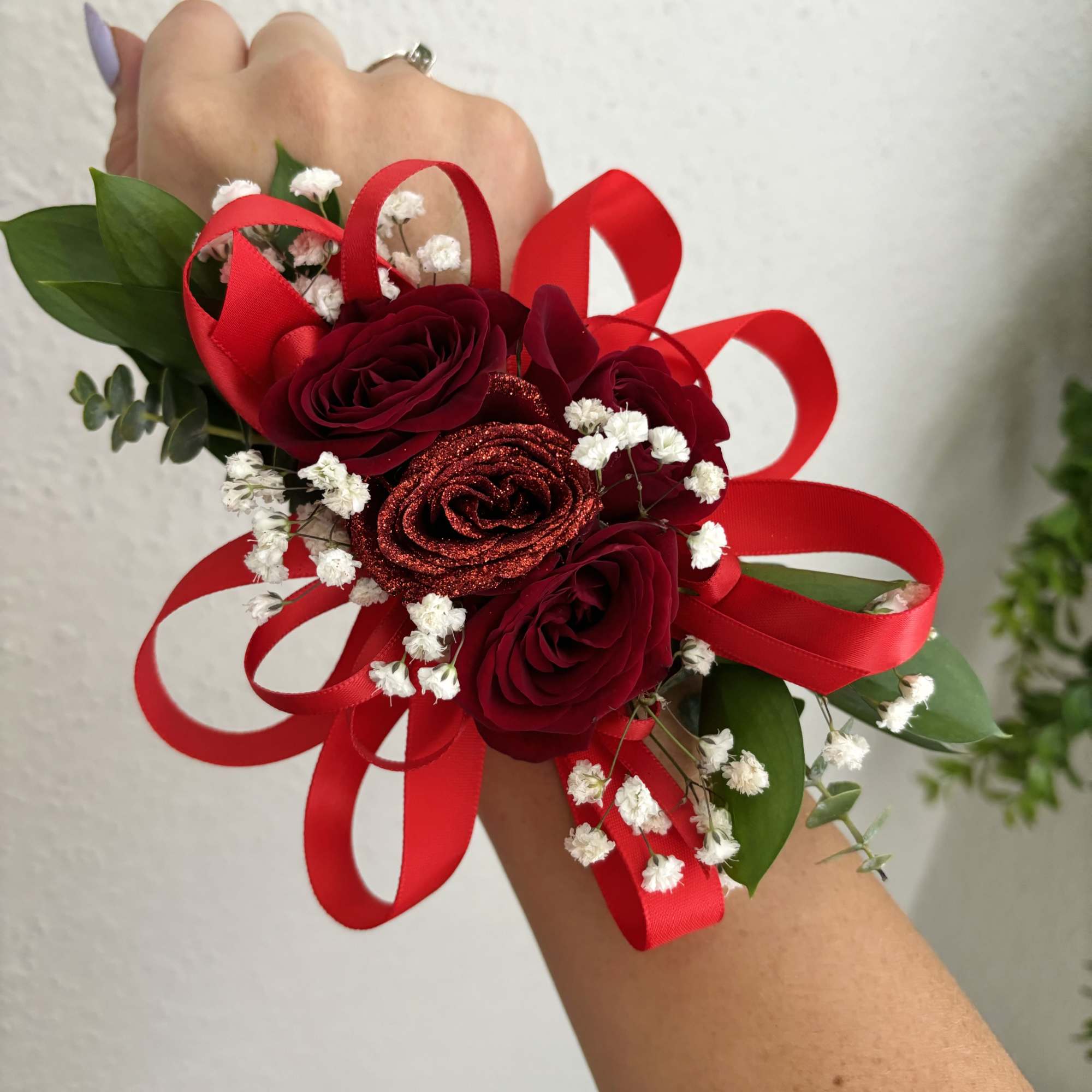 Red rose wrist corsage with baby's breath and ribbon loops
