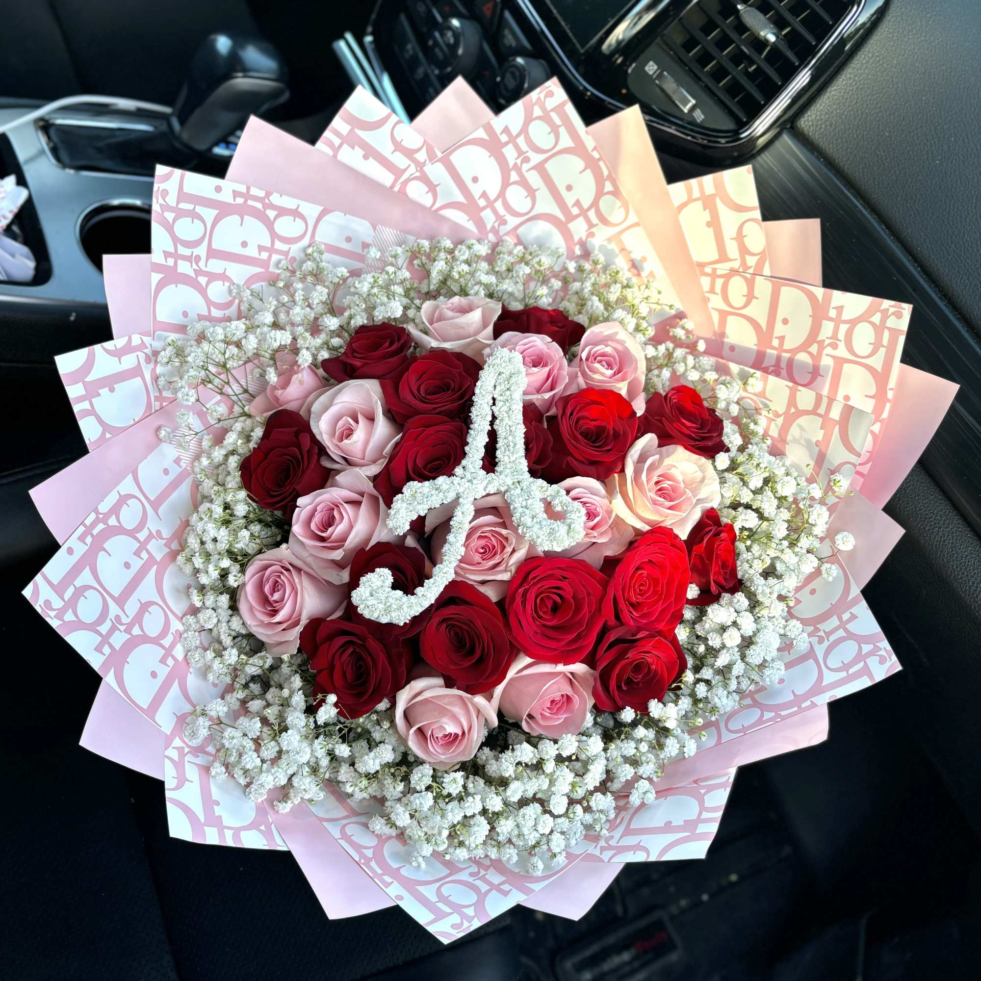 Bouquet of red and pink roses with baby's breath in pink wrapping