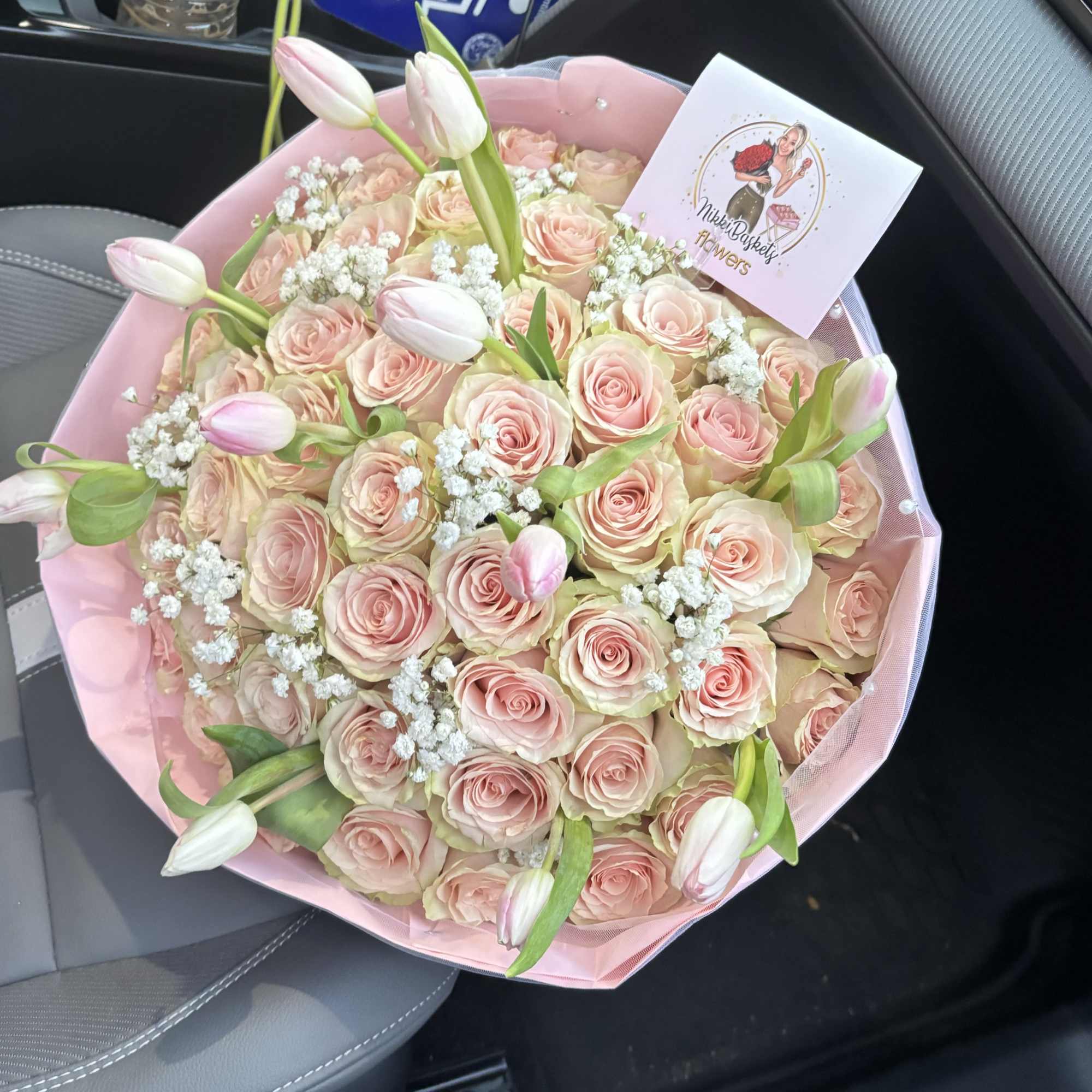 Bouquet of pale pink roses with white tulips and baby's breath in pink wrap