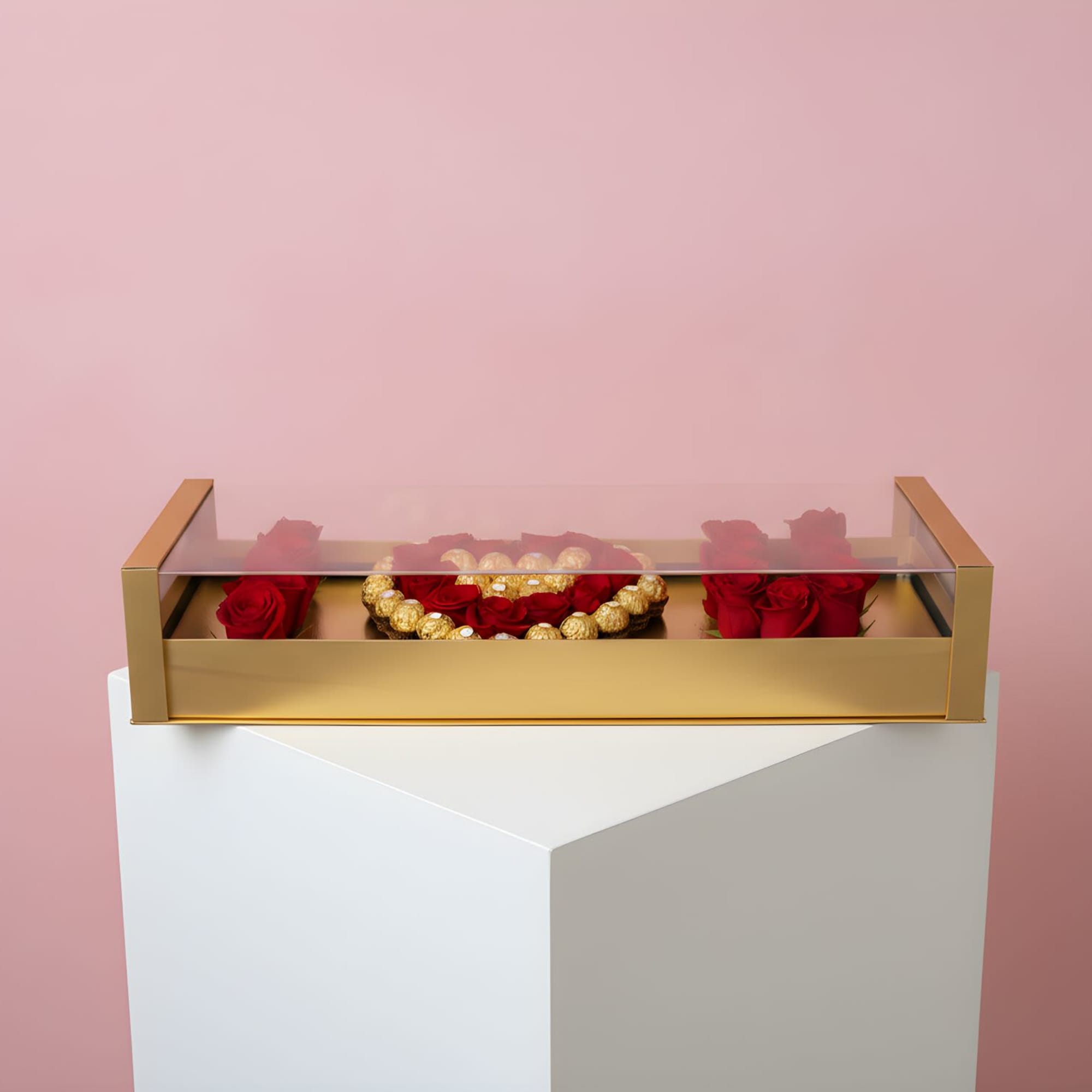 Red roses arranged in a gold box with a clear lid