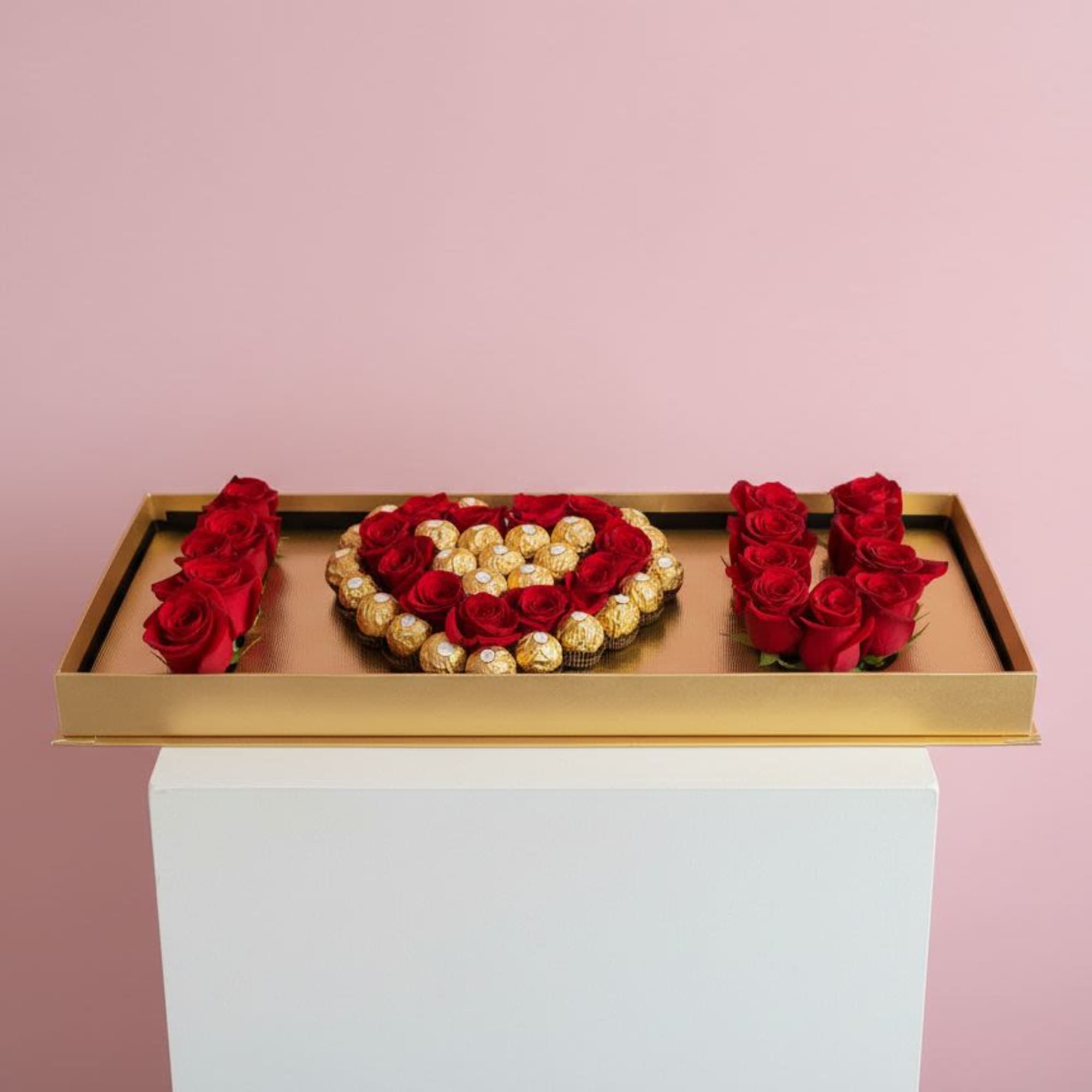 Gold tray with red roses and Ferrero Rocher chocolates arranged in a heart