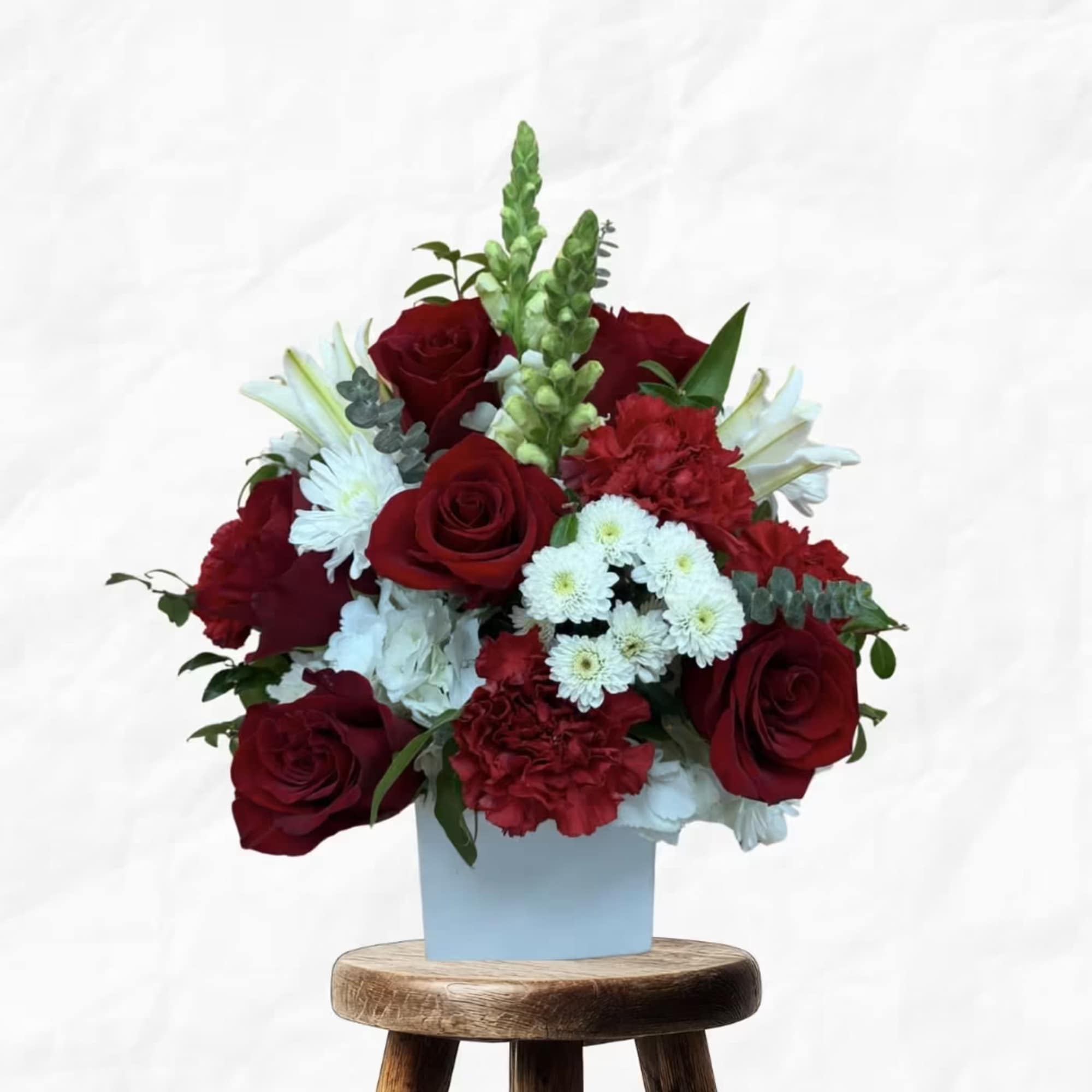 Red roses and white flowers in a light blue box