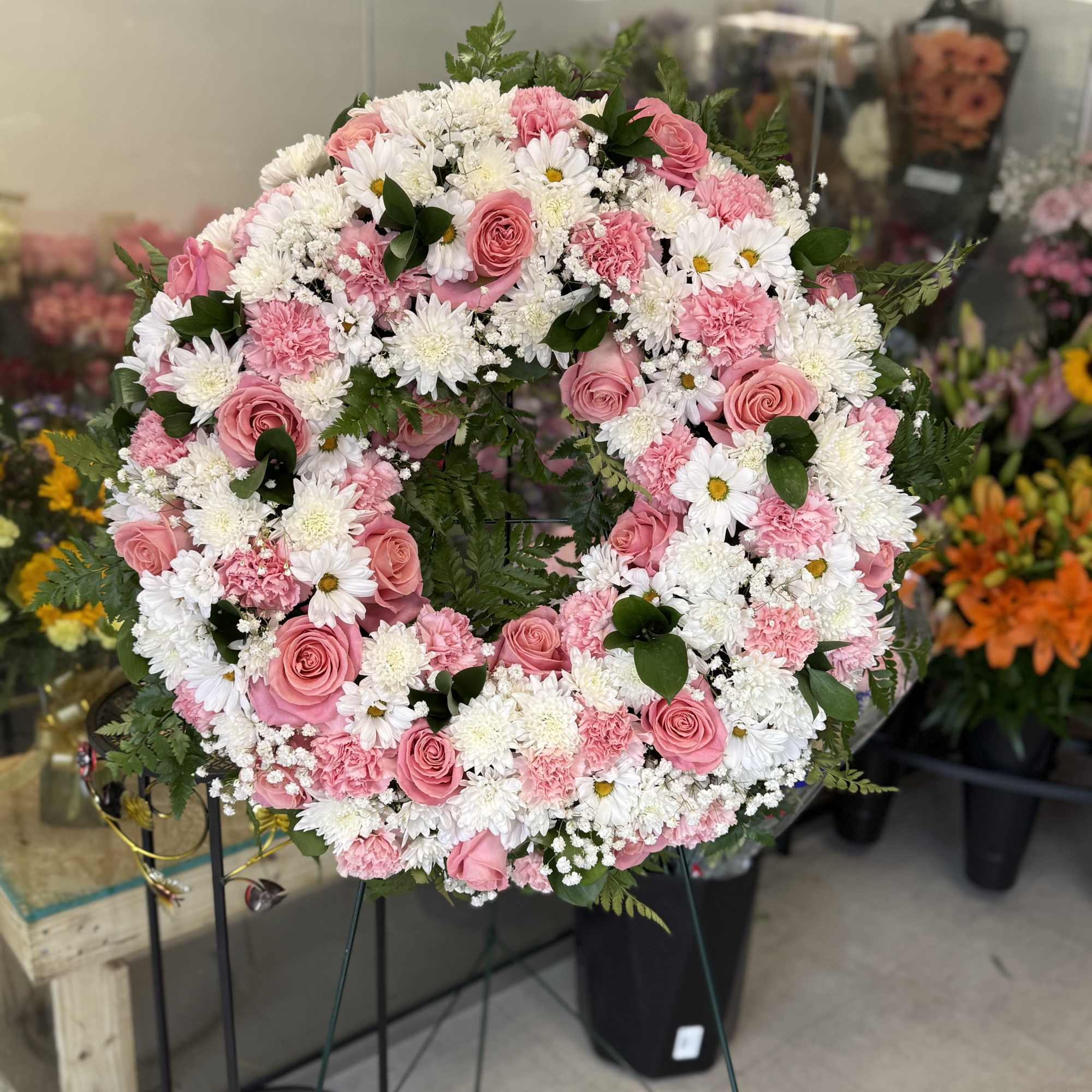 Pink and white floral wreath on a stand