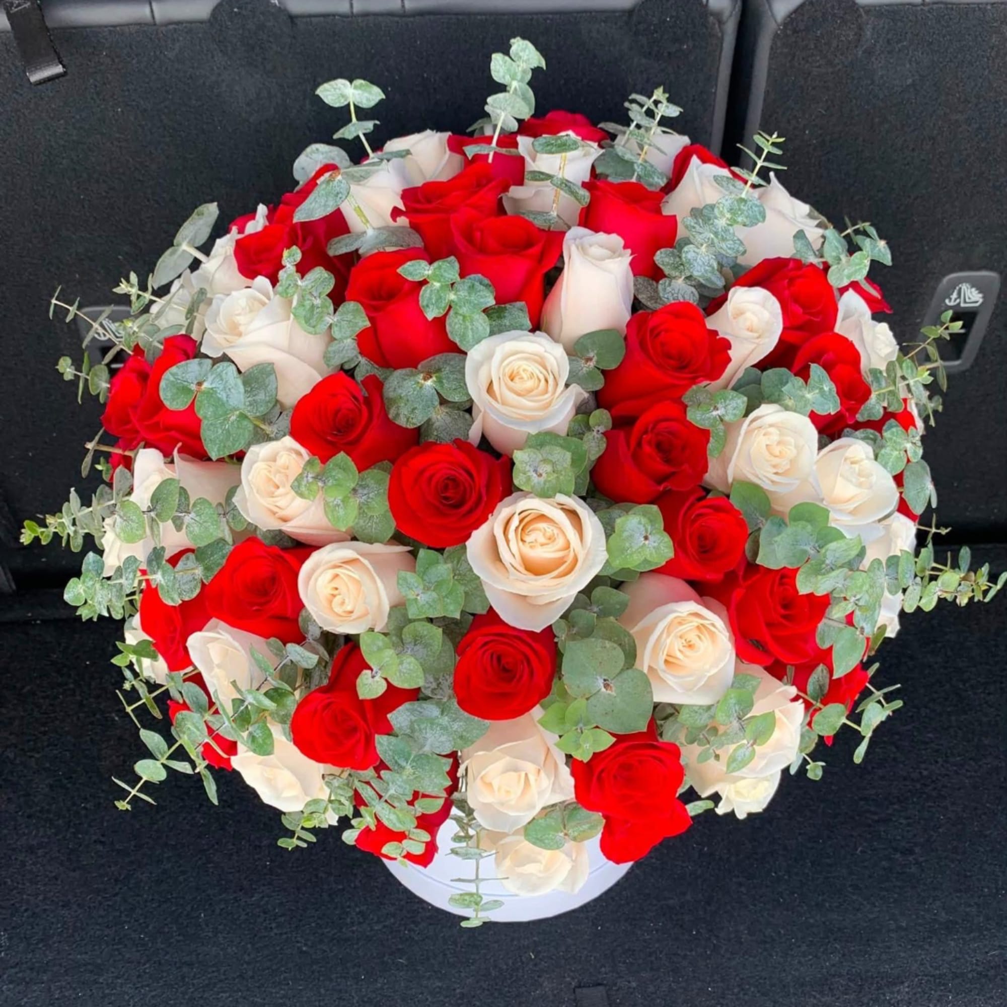 Bouquet of red and white roses with eucalyptus in a white box