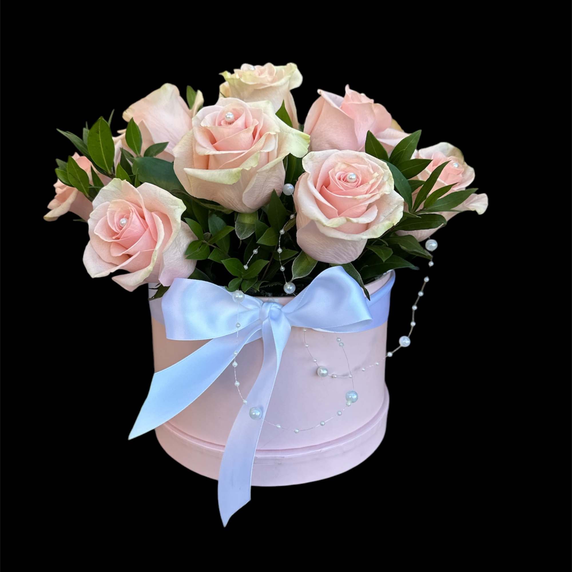 Pink roses in a pastel hat box with a blue ribbon