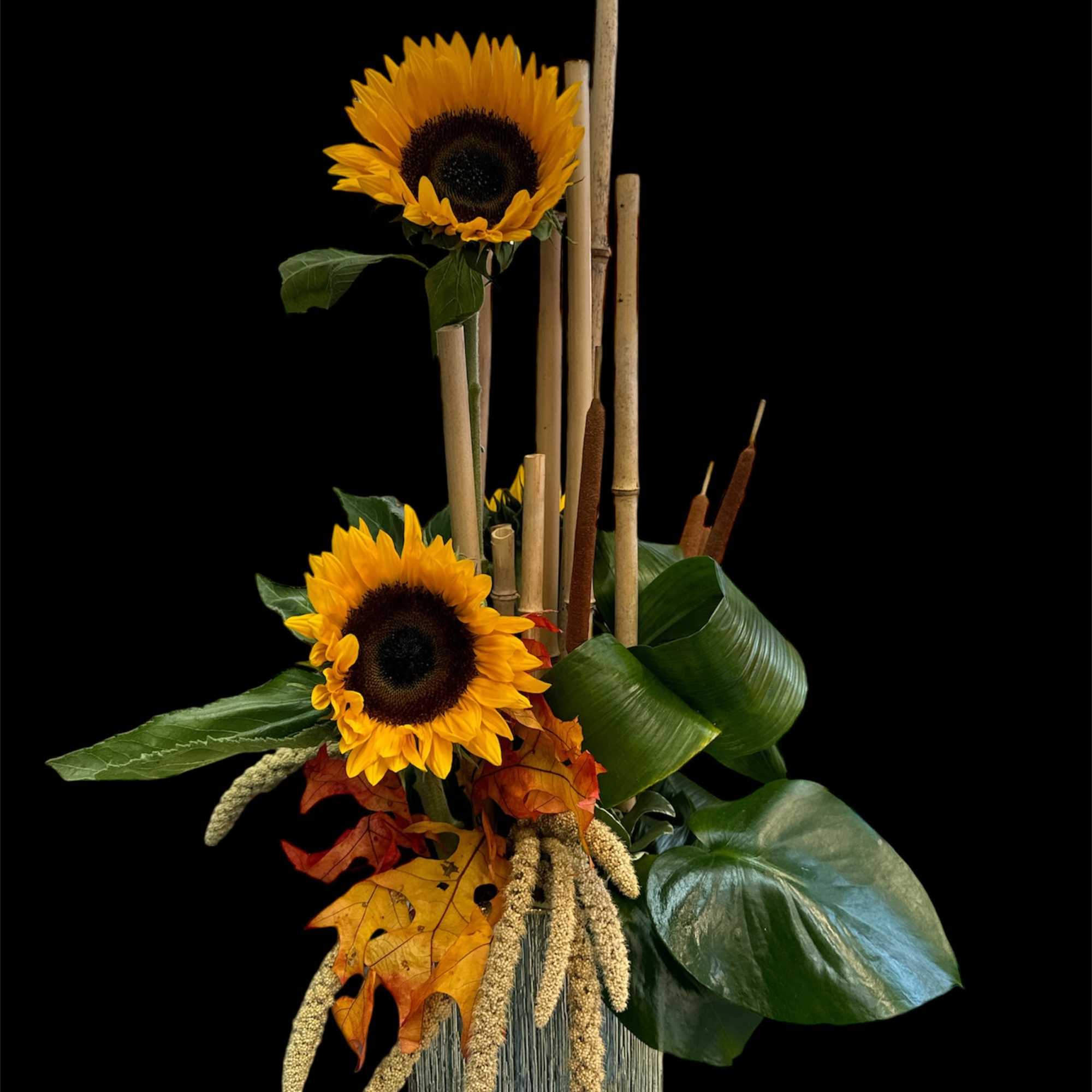 Sunflower arrangement with autumn leaves and bamboo sticks