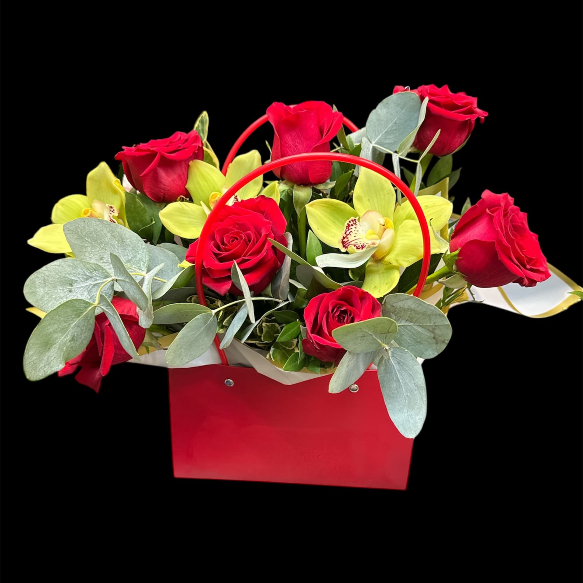 Red roses and yellow orchids in a red handled gift bag