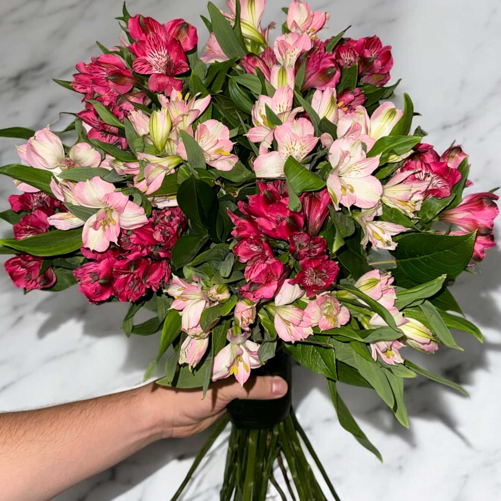 Bouquet of pink and magenta alstroemeria flowers with green foliage