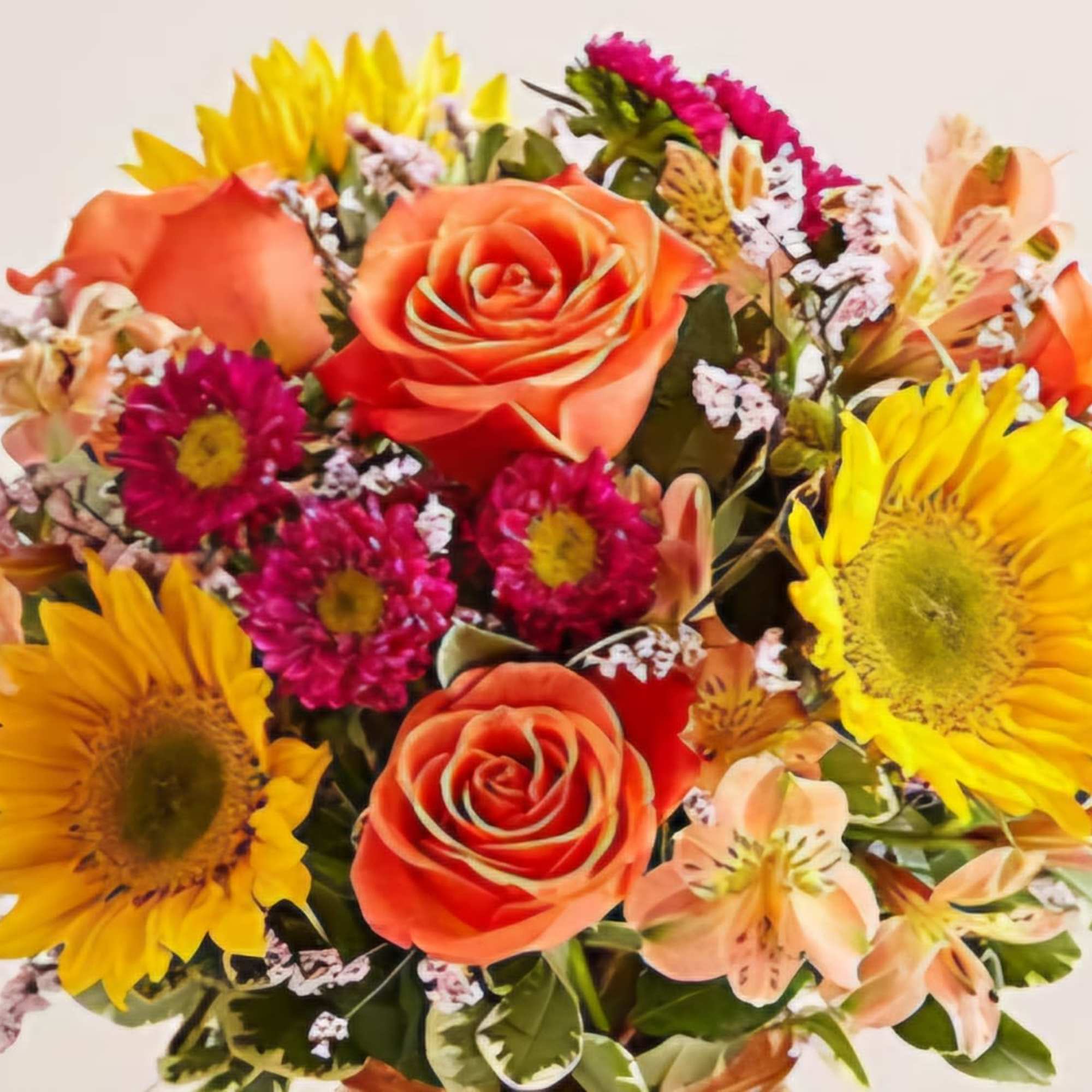 Bouquet of orange roses, sunflowers, and pink filler flowers