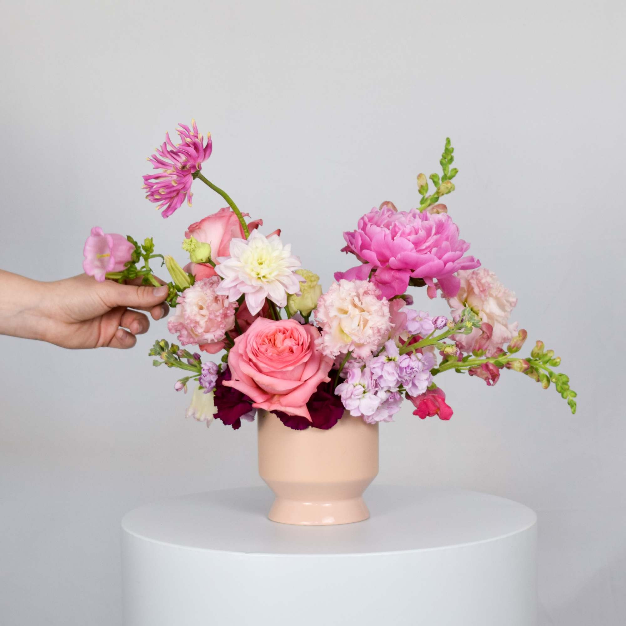 Pink and white mixed bouquet in a peach vase