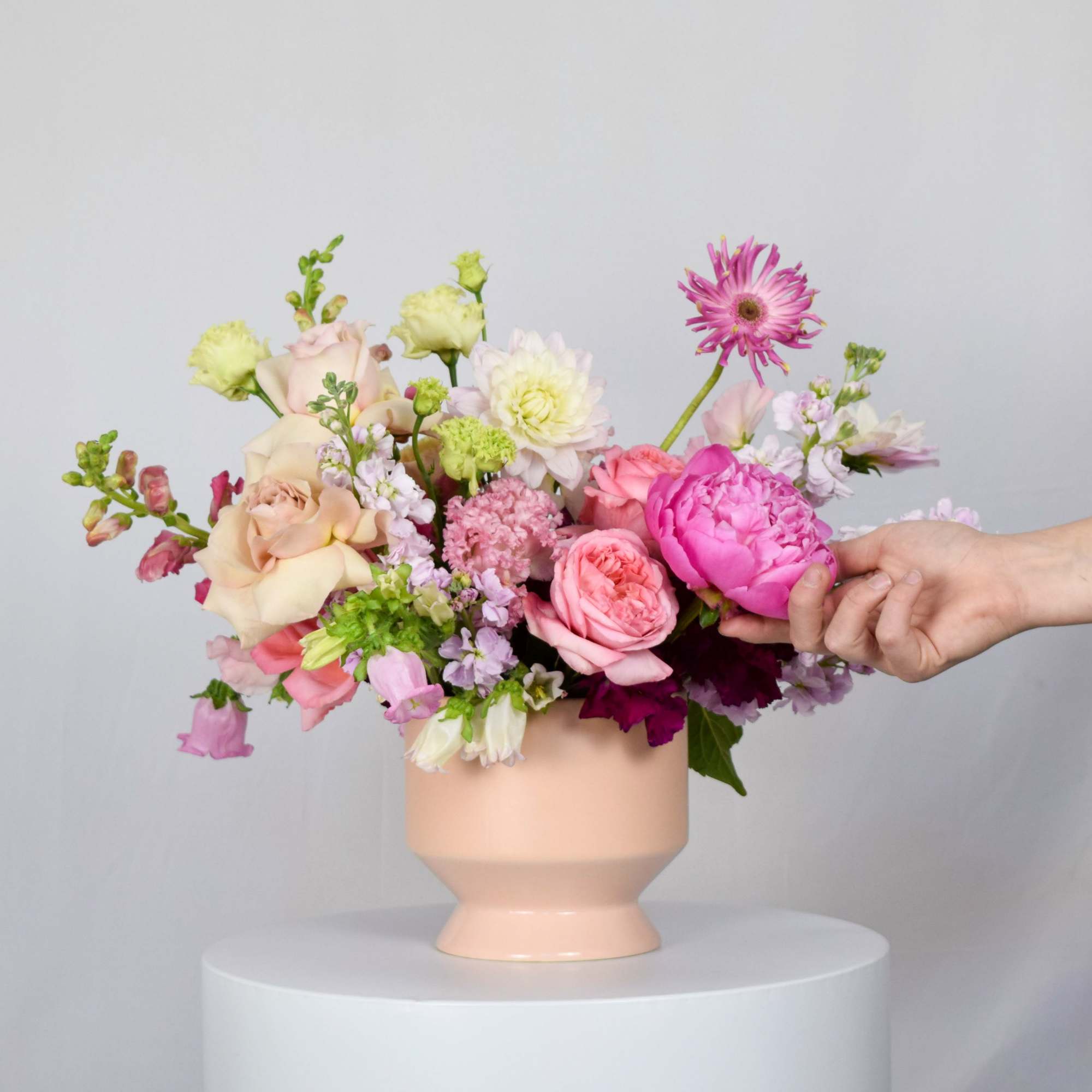 Pink and cream mixed bouquet in a peach vase