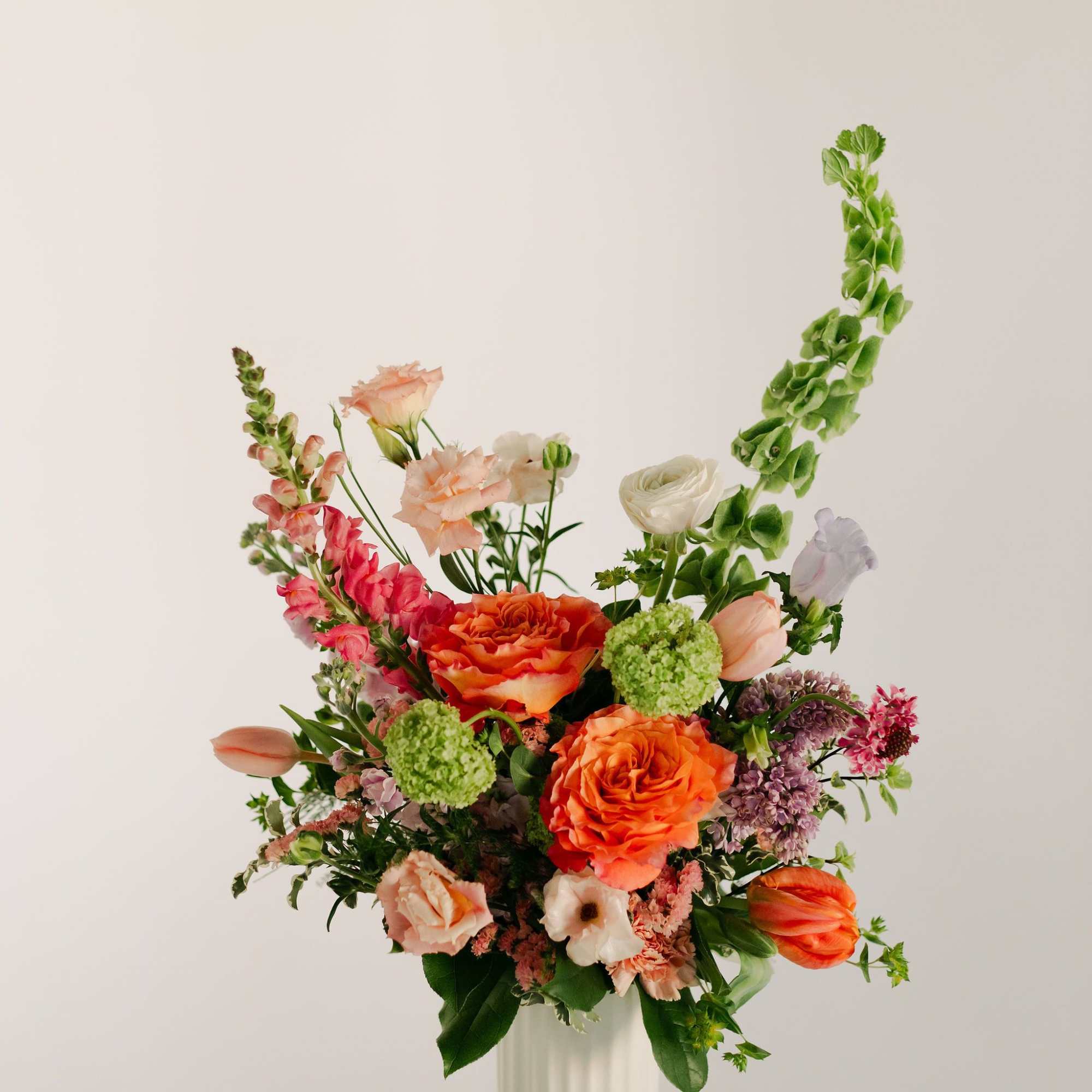 A lush blend of peaches, blush pinks, soft lavenders, and fresh greens, photo 2 of 4