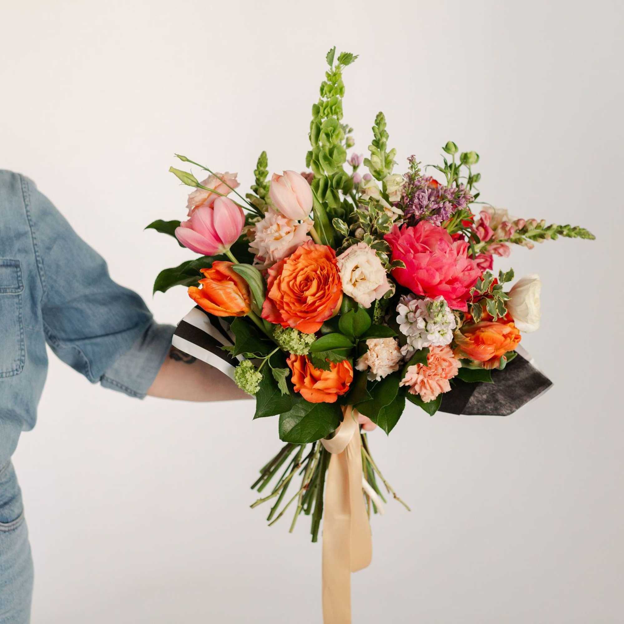 A stunning, premium hand-tied arrangement including coral charm peonies, fluffy lisianthus, lush