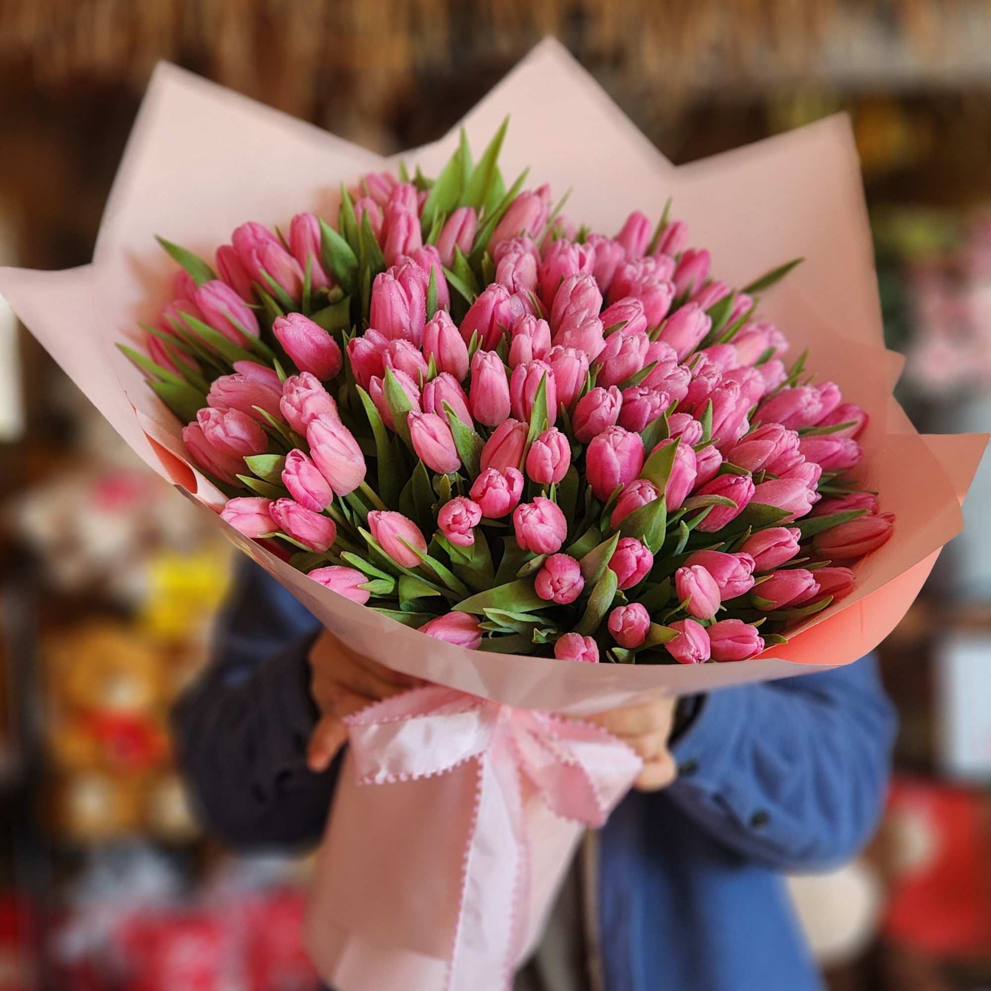 Bouquet of pink tulips wrapped in pale pink paper with a ribbon