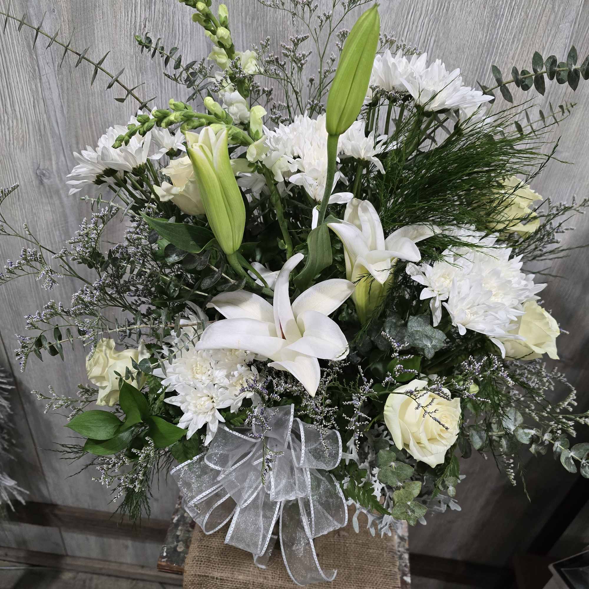 A beautiful vase arrangement full of white ivory blooms and lilies. Additional, photo 2 of 2