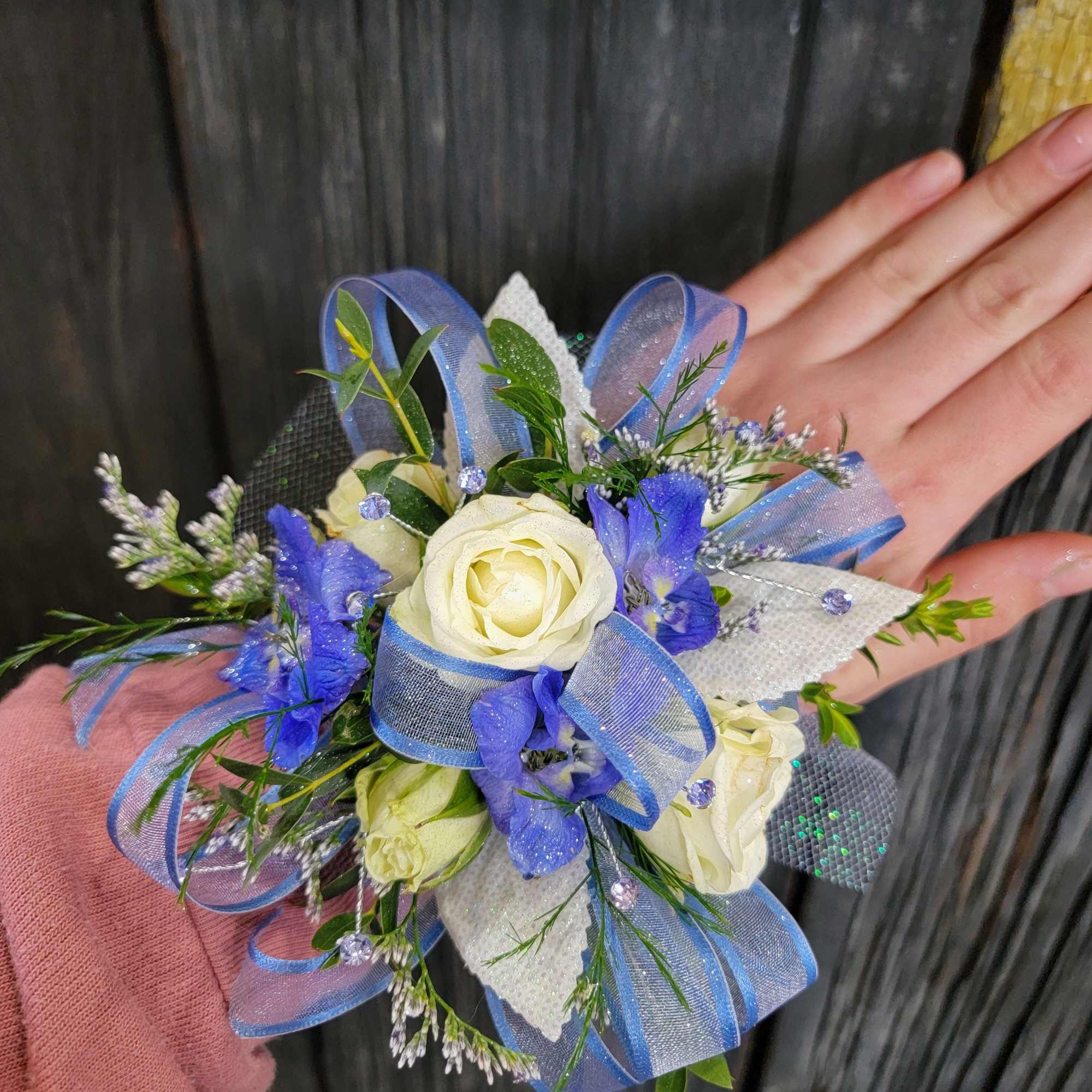 A beautiful corsage with blue tones made with your choice of flowers.