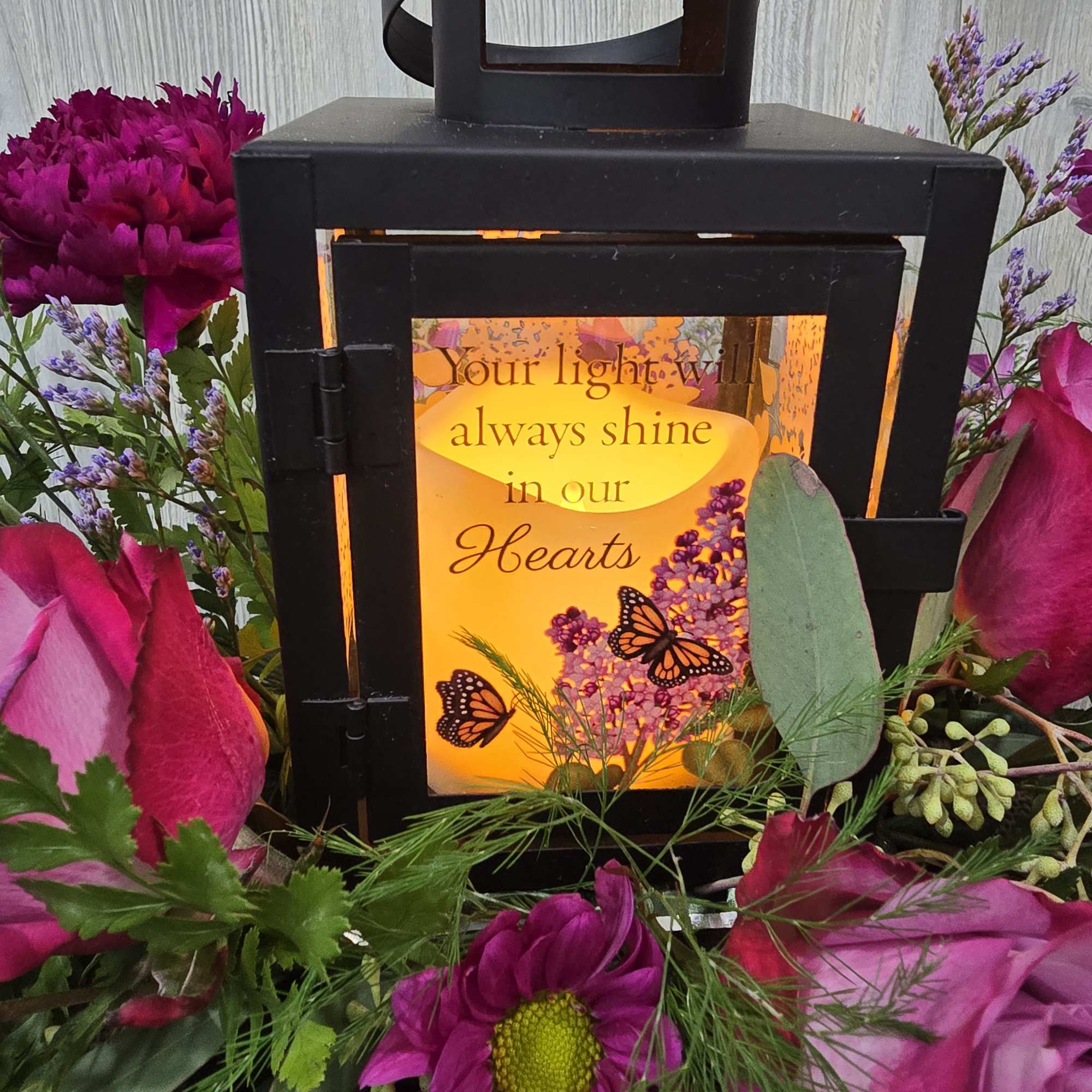A beautiful lantern sympathy arrangement with a ray of purple tone flowers., photo 2 of 2