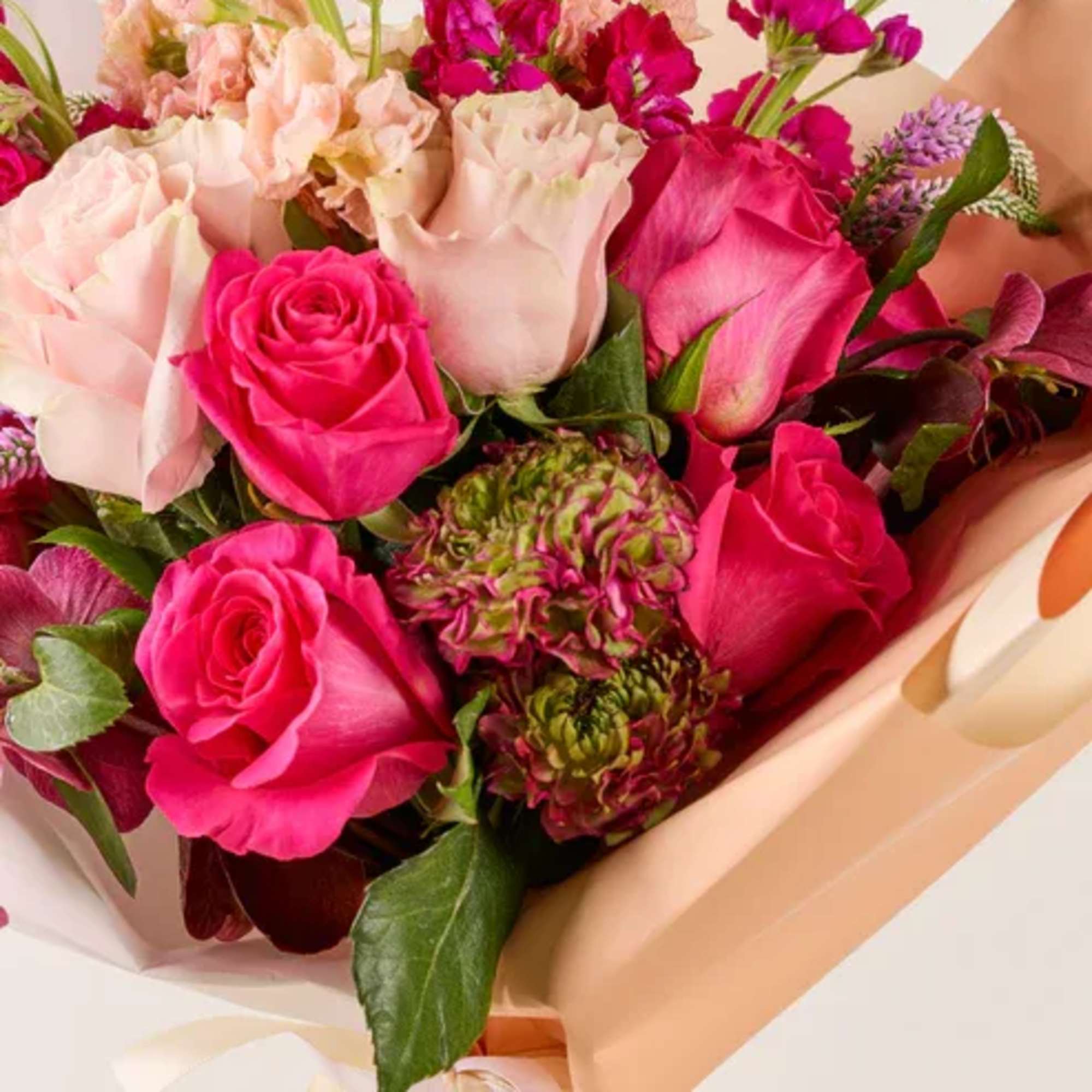 Bouquet of pink and blush roses with peach wrapping