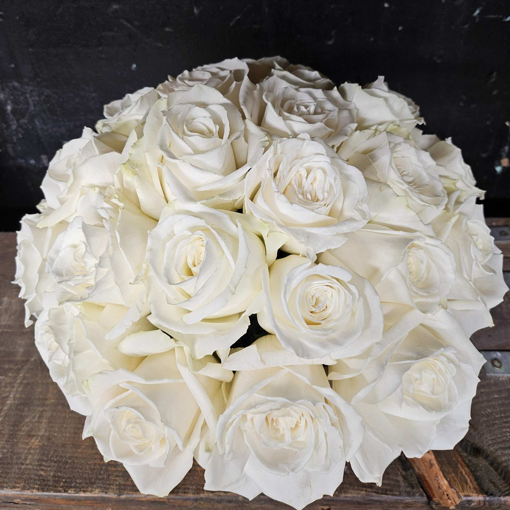 Round bouquet of white roses on a dark background