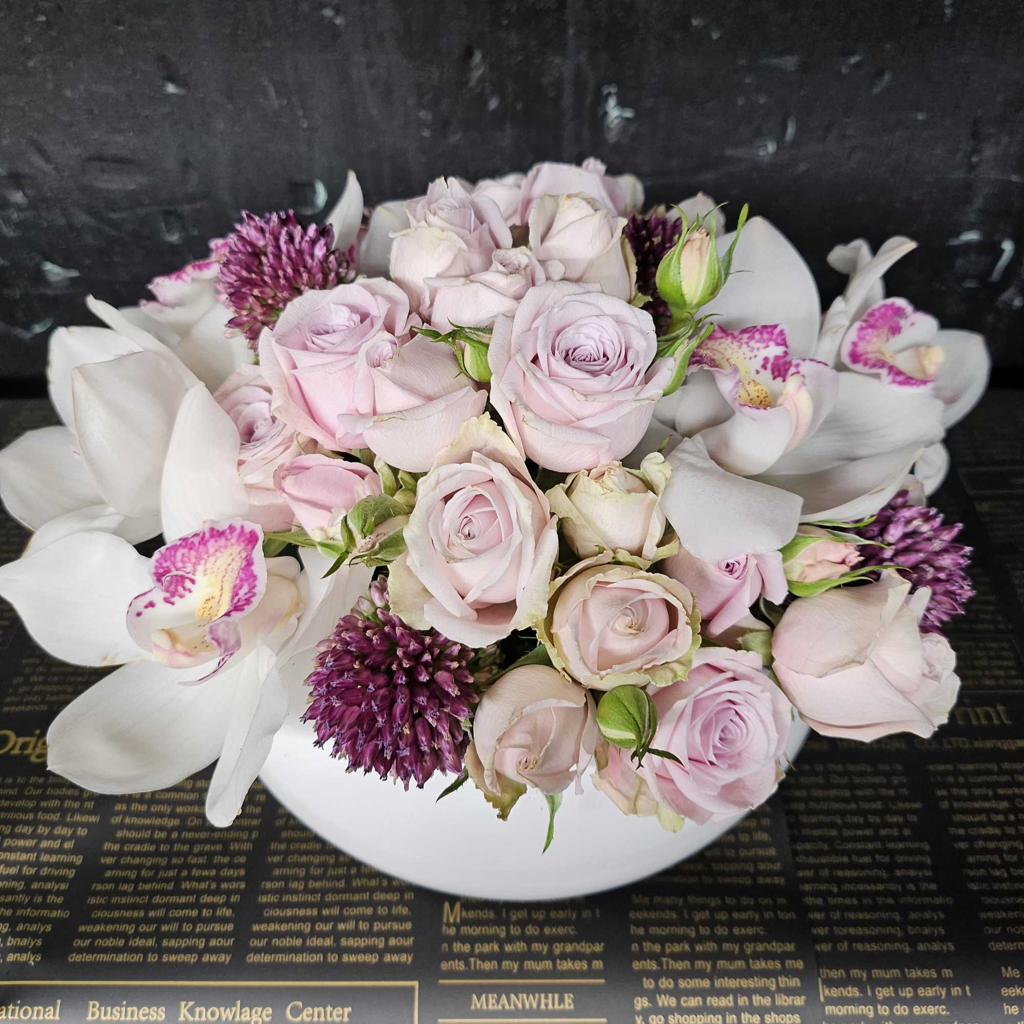 Bouquet of pale pink roses and white orchids on a white plate