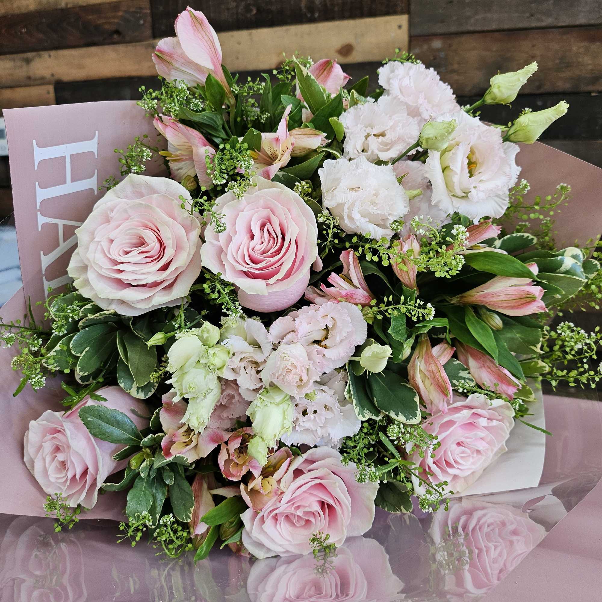 Pink roses and white blooms in a wrapped bouquet