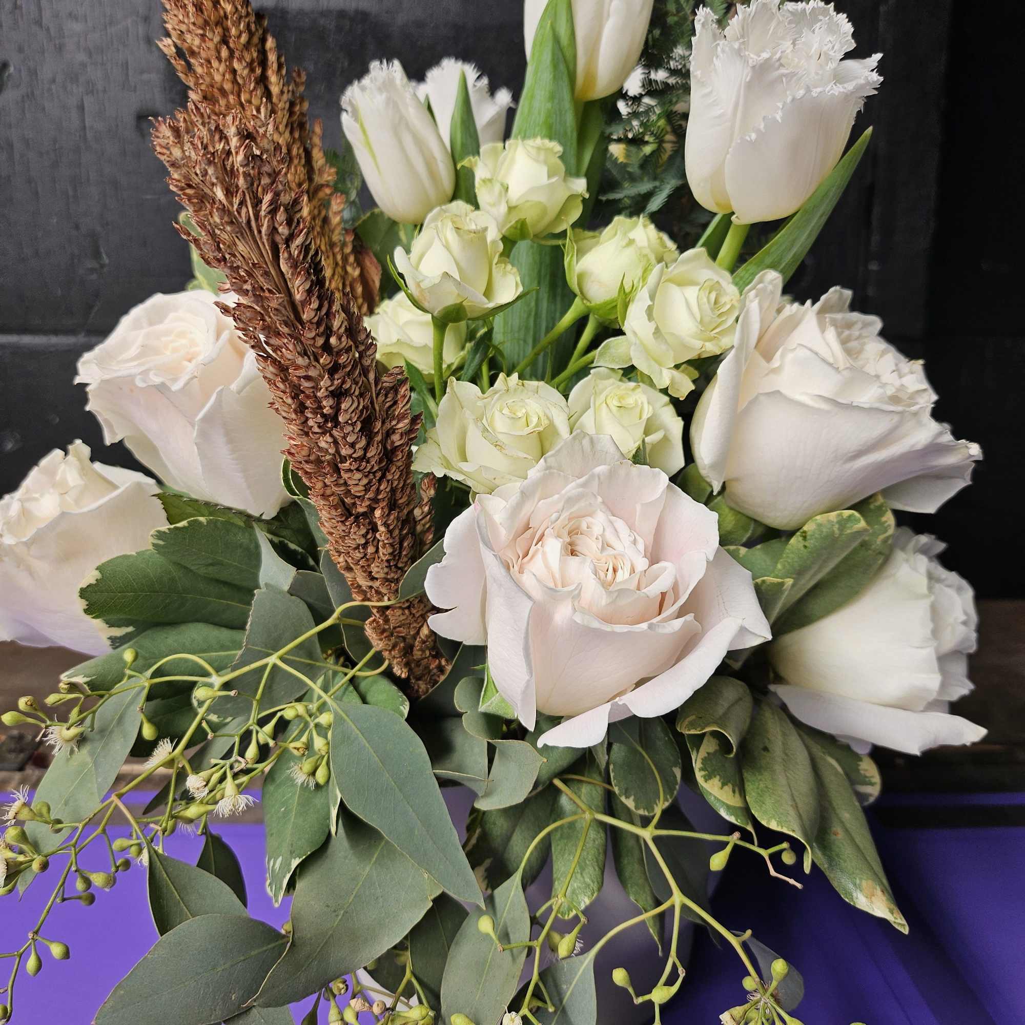 Bouquet of white roses and tulips with greenery