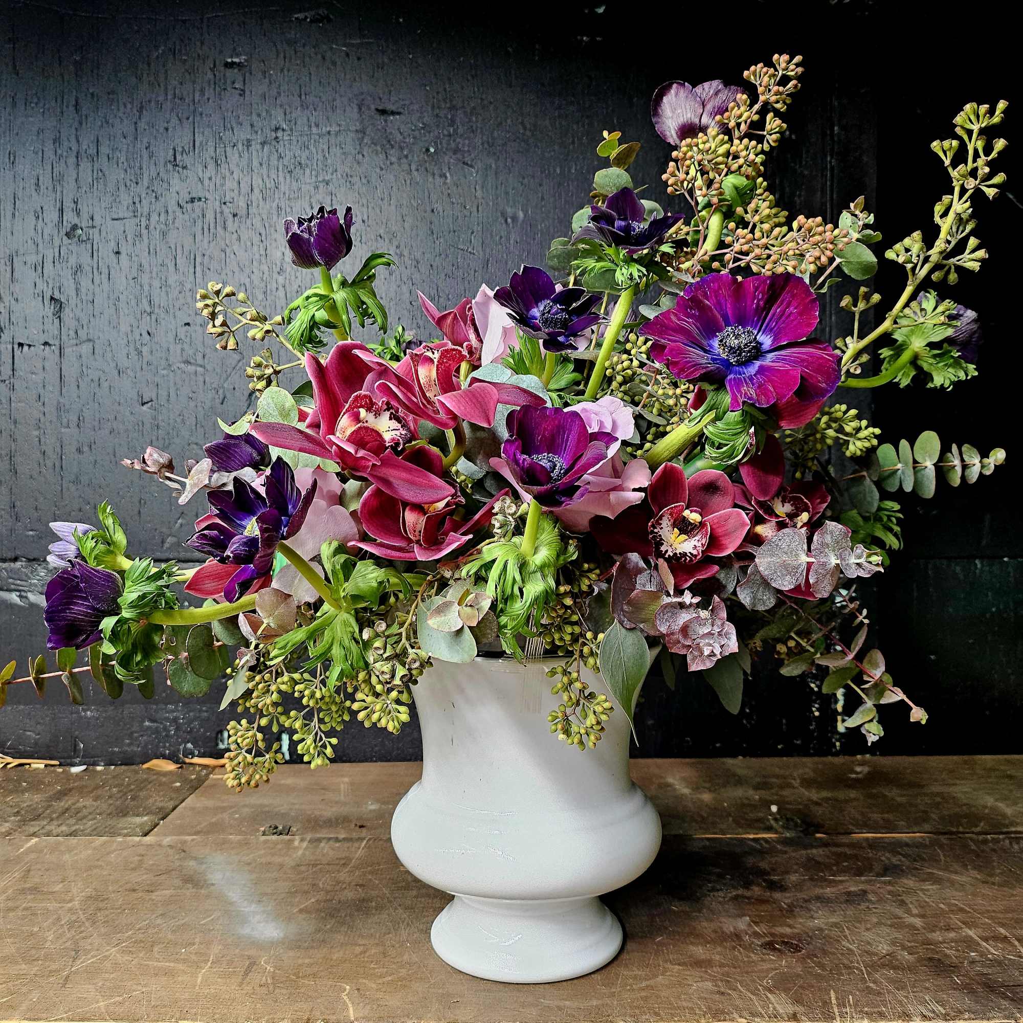 Purple and pink floral arrangement in a white vase