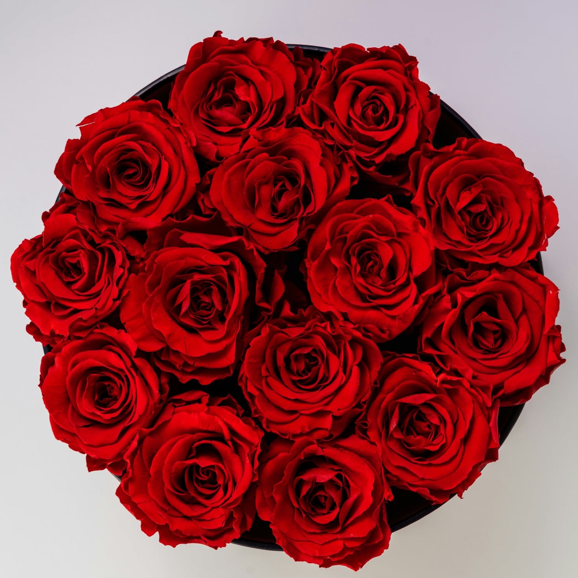 Round bouquet of red roses in a black box