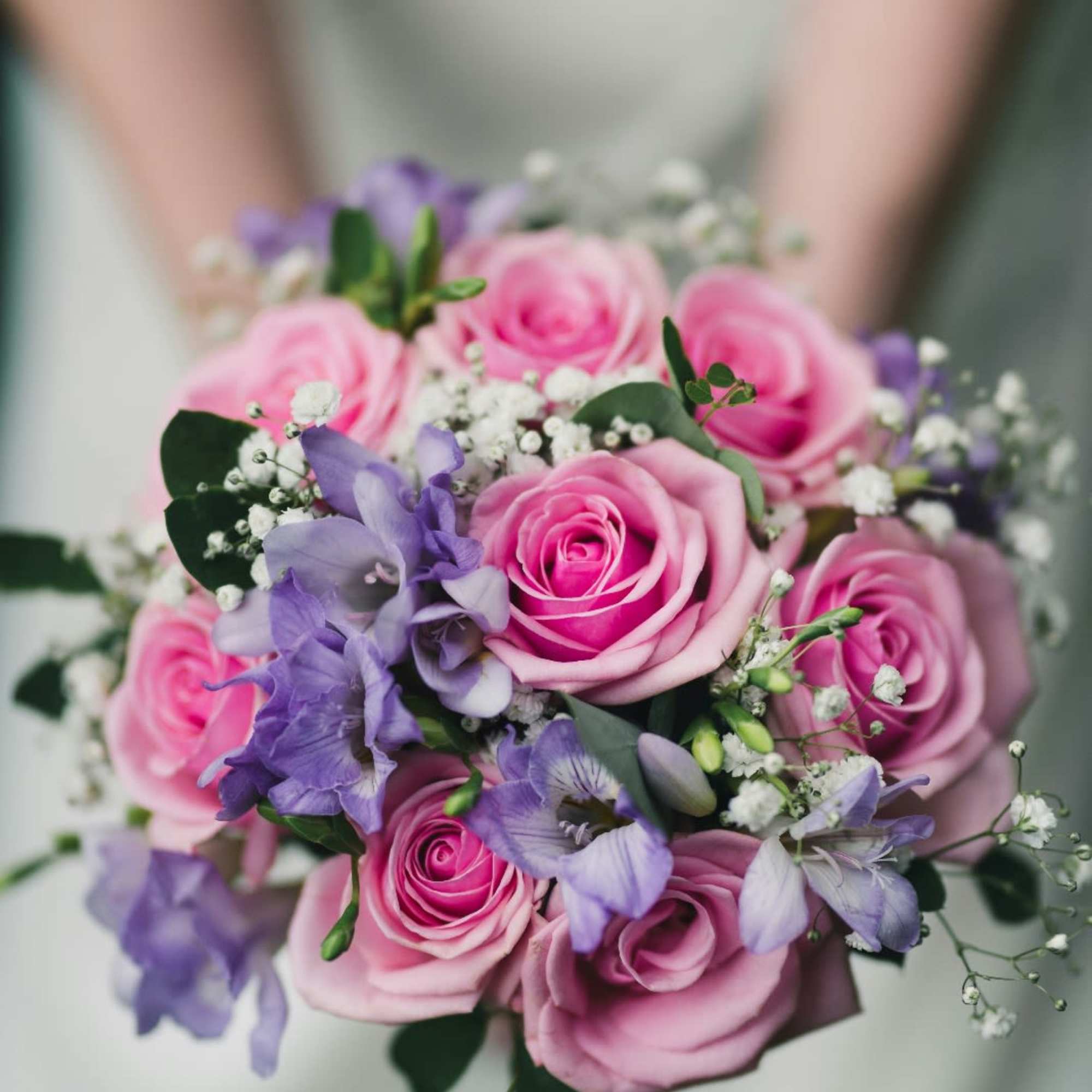 Pink and purple bridal bouquet with roses and small filler flowers