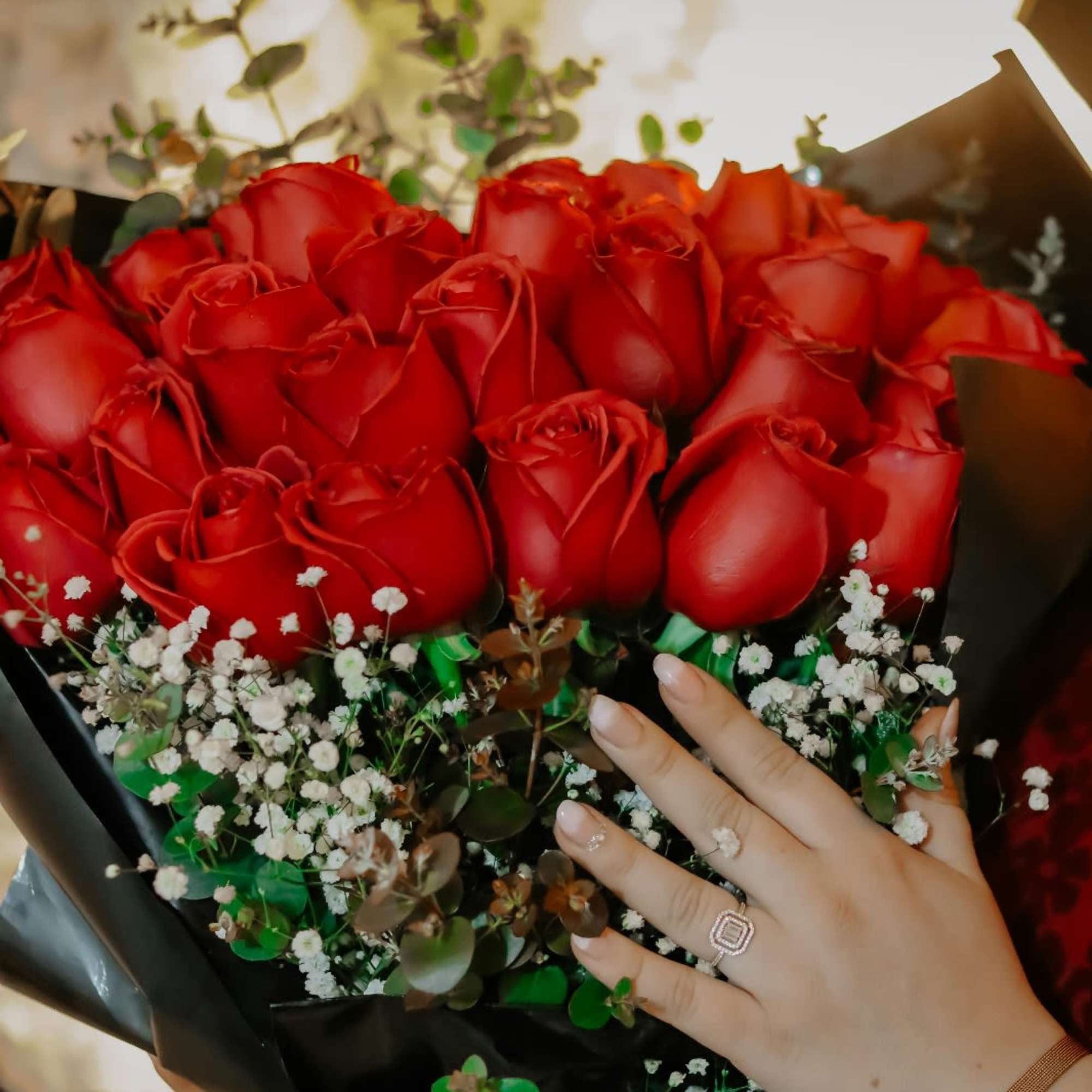 Bouquet of red roses with baby's breath in black wrap
