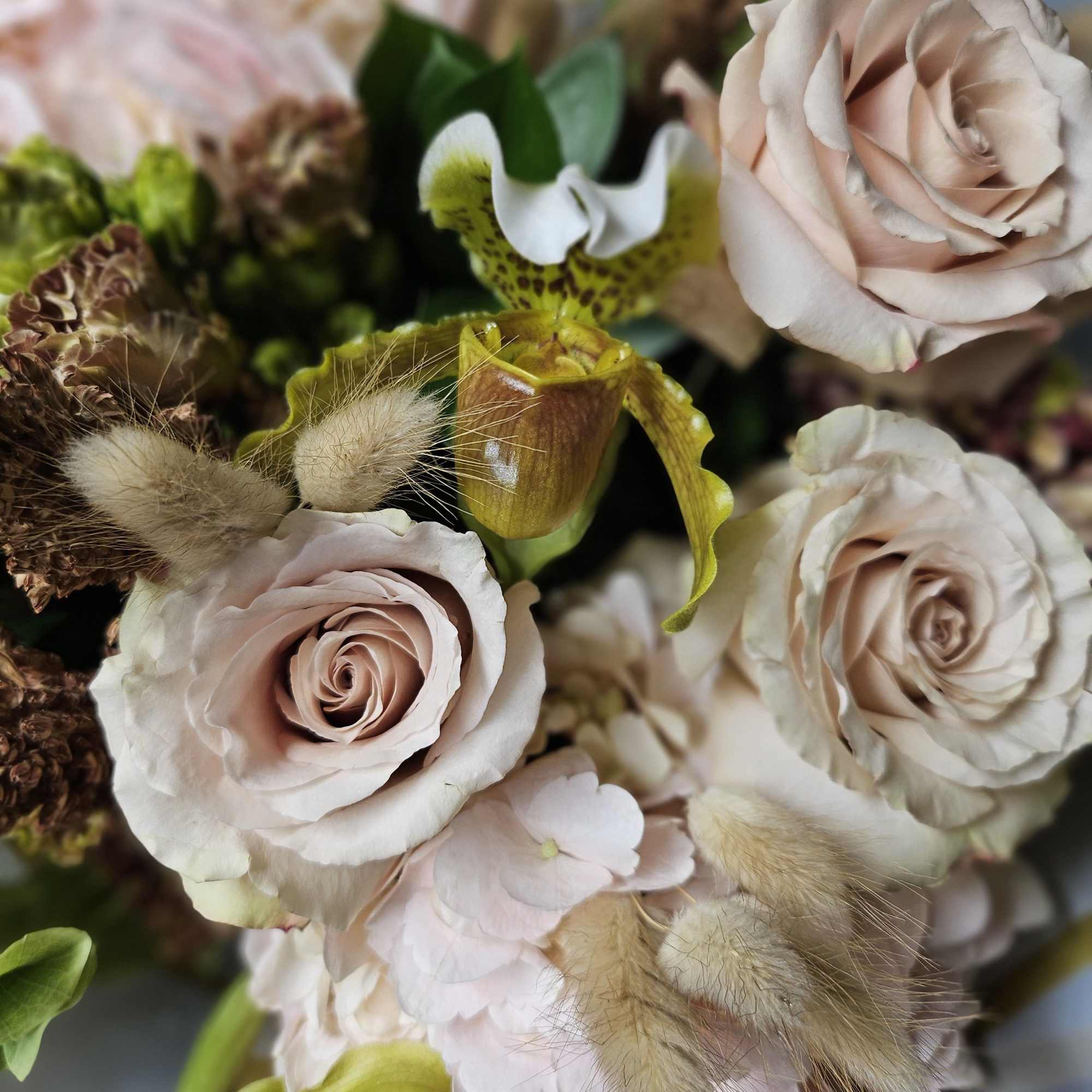 Bouquet of pale pink roses with spotted orchids and fluffy accents