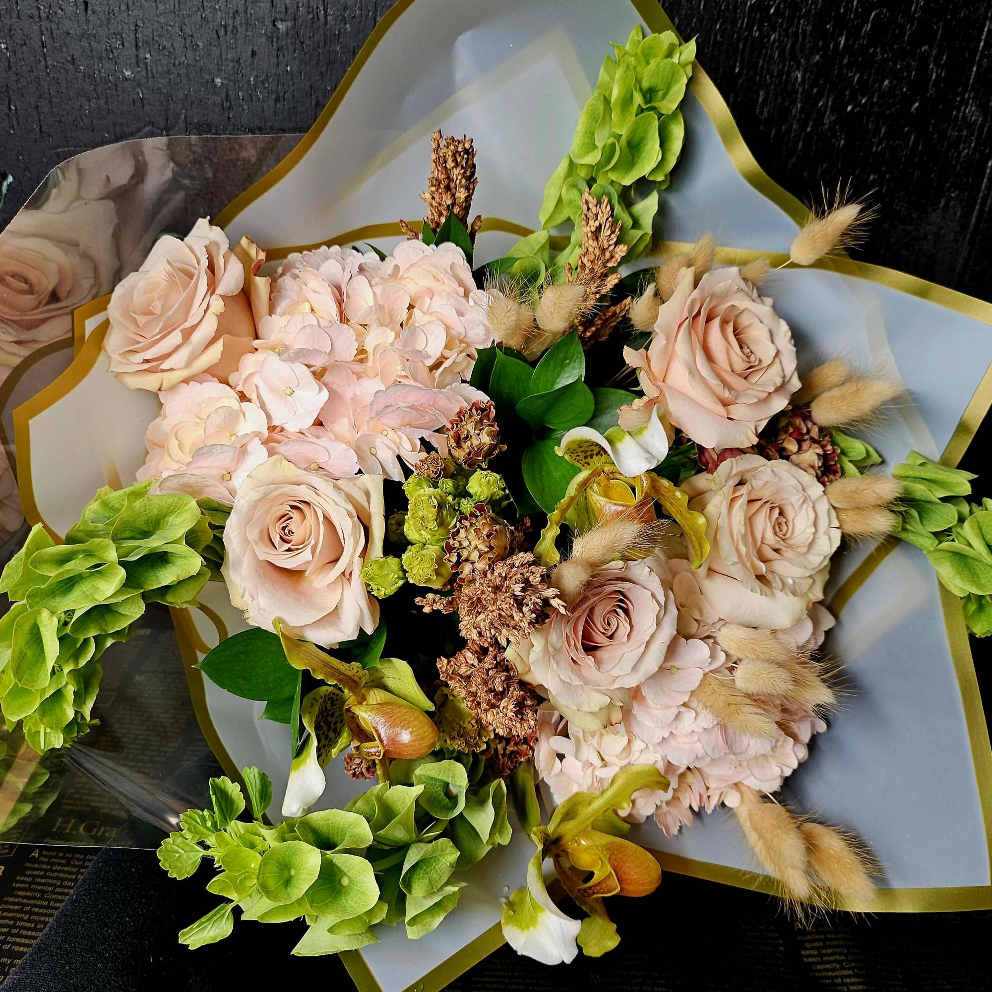 Bouquet of blush roses, pale pink hydrangeas, and green orchids