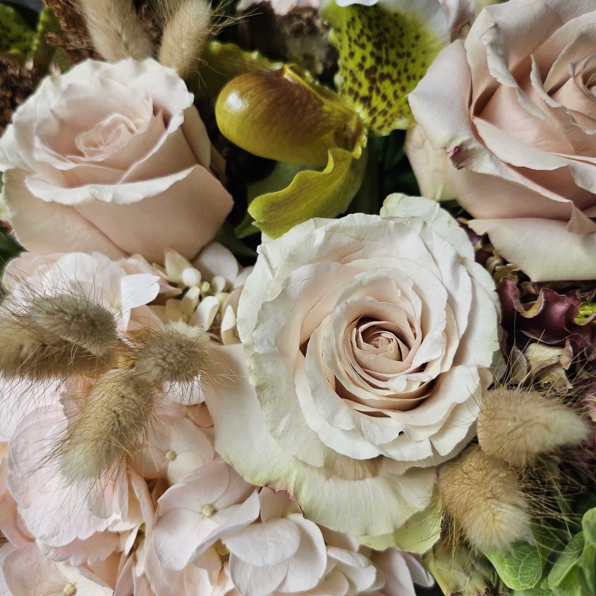 Blush roses and pale hydrangeas with fuzzy grass accents
