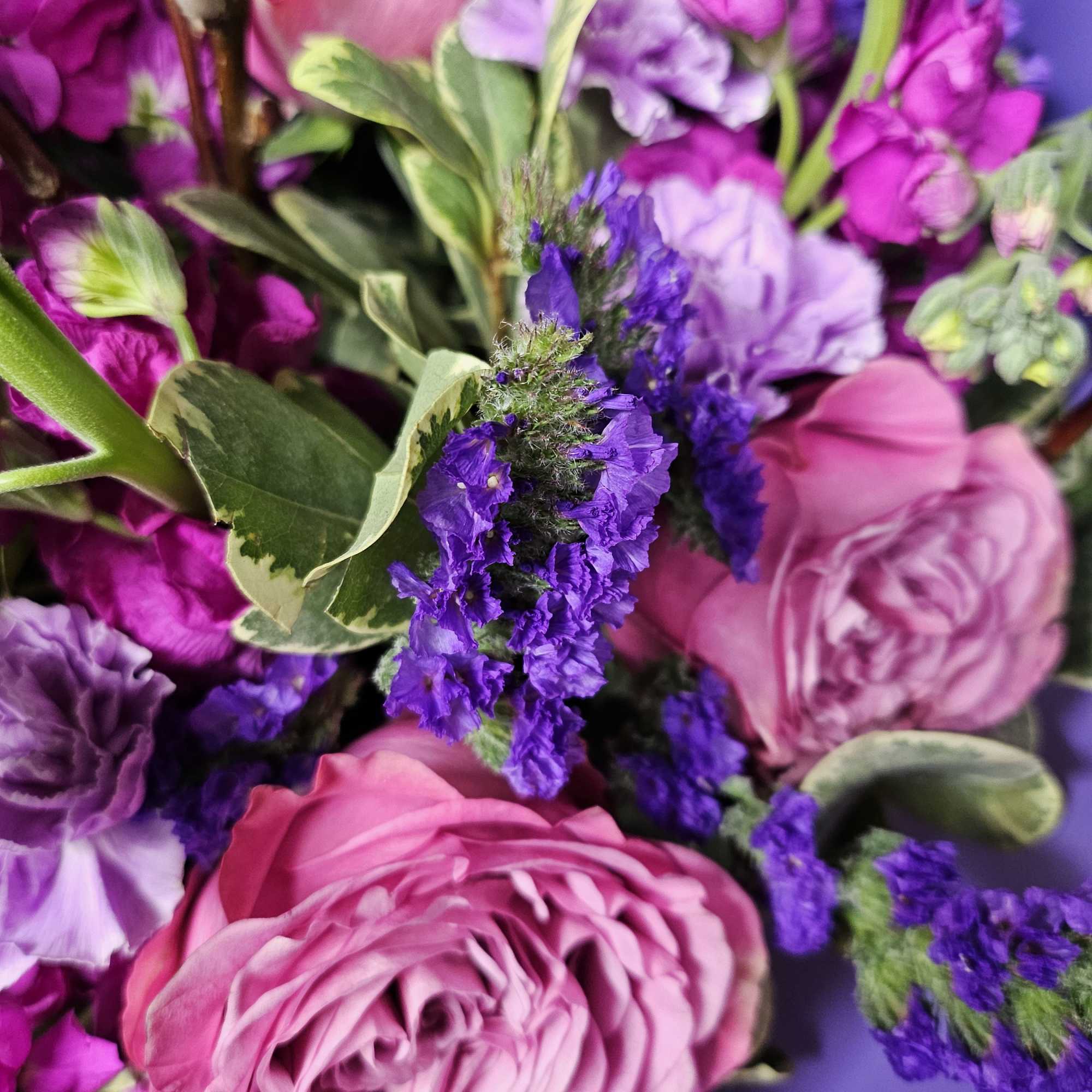 Pink and purple bouquet of roses and ruffled blooms