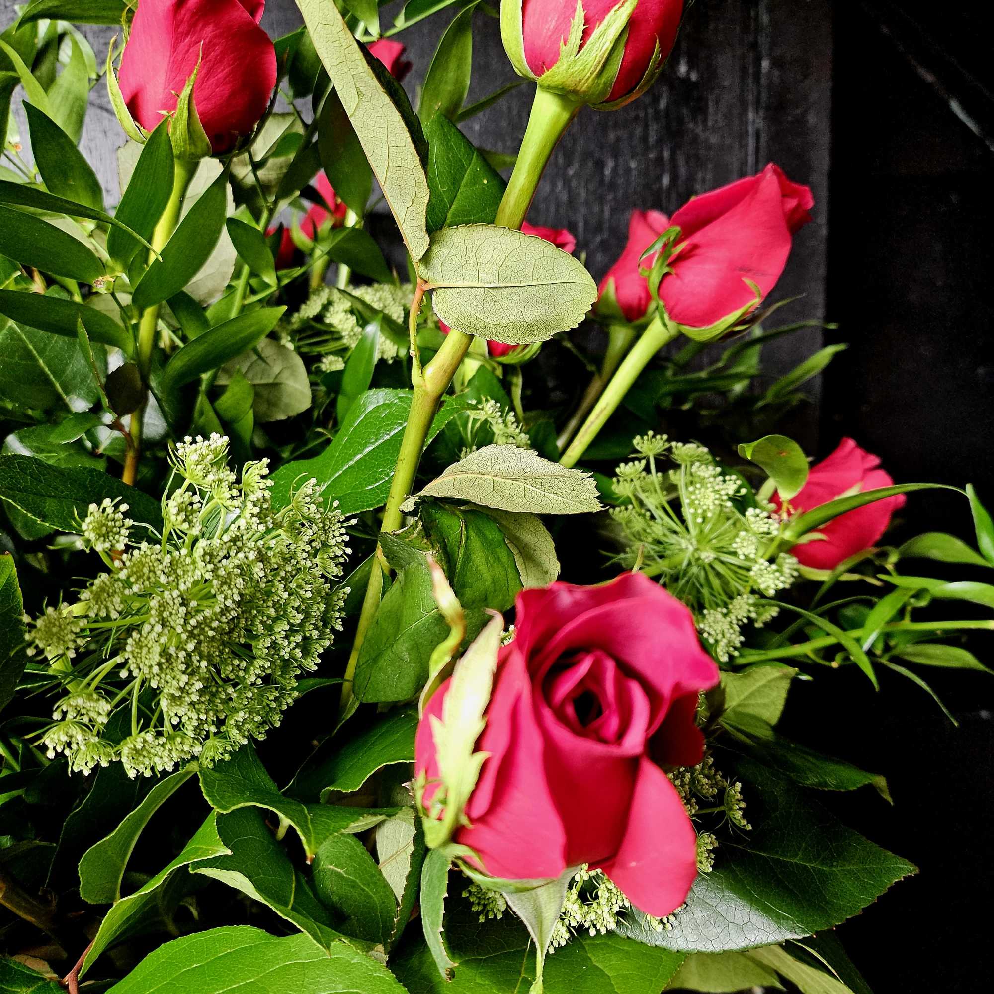 Bouquet of hot pink roses with greenery and white filler flowers