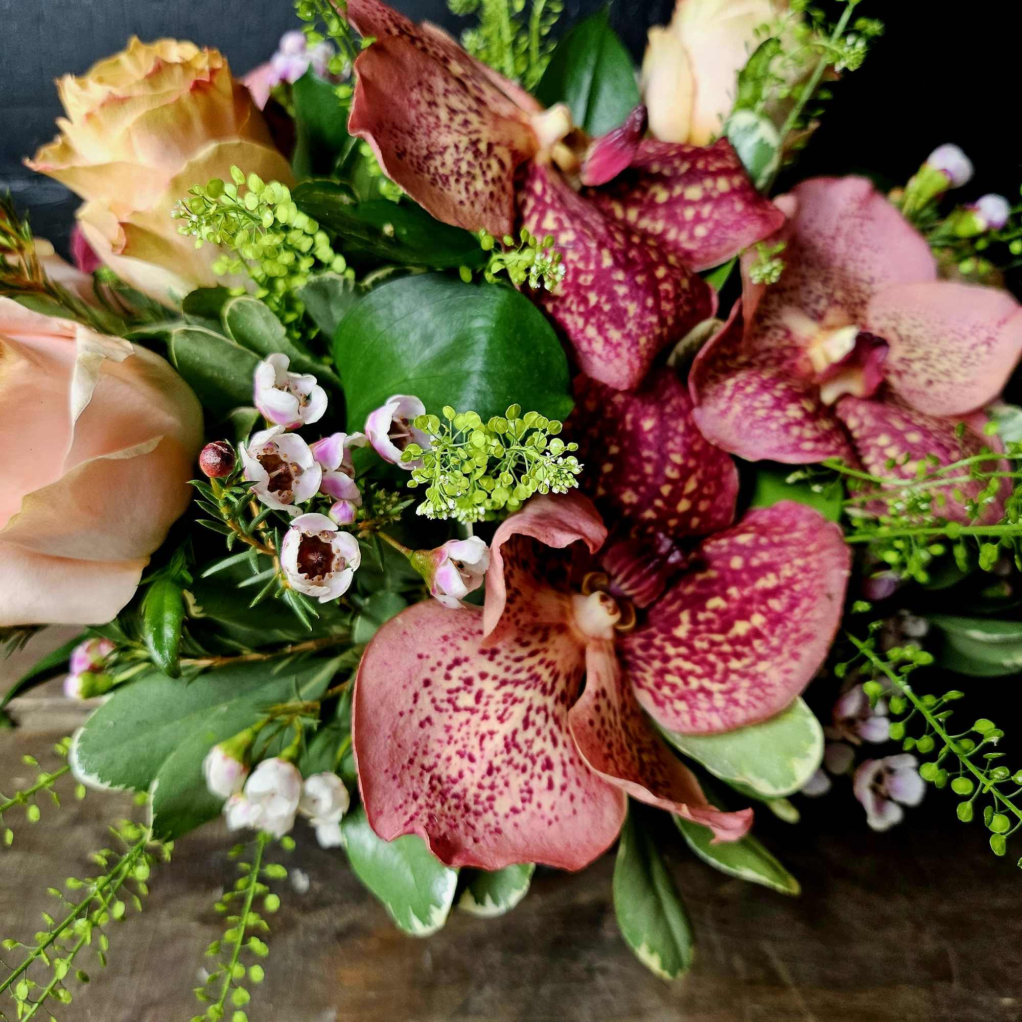 Bouquet of pink speckled orchids and peach roses