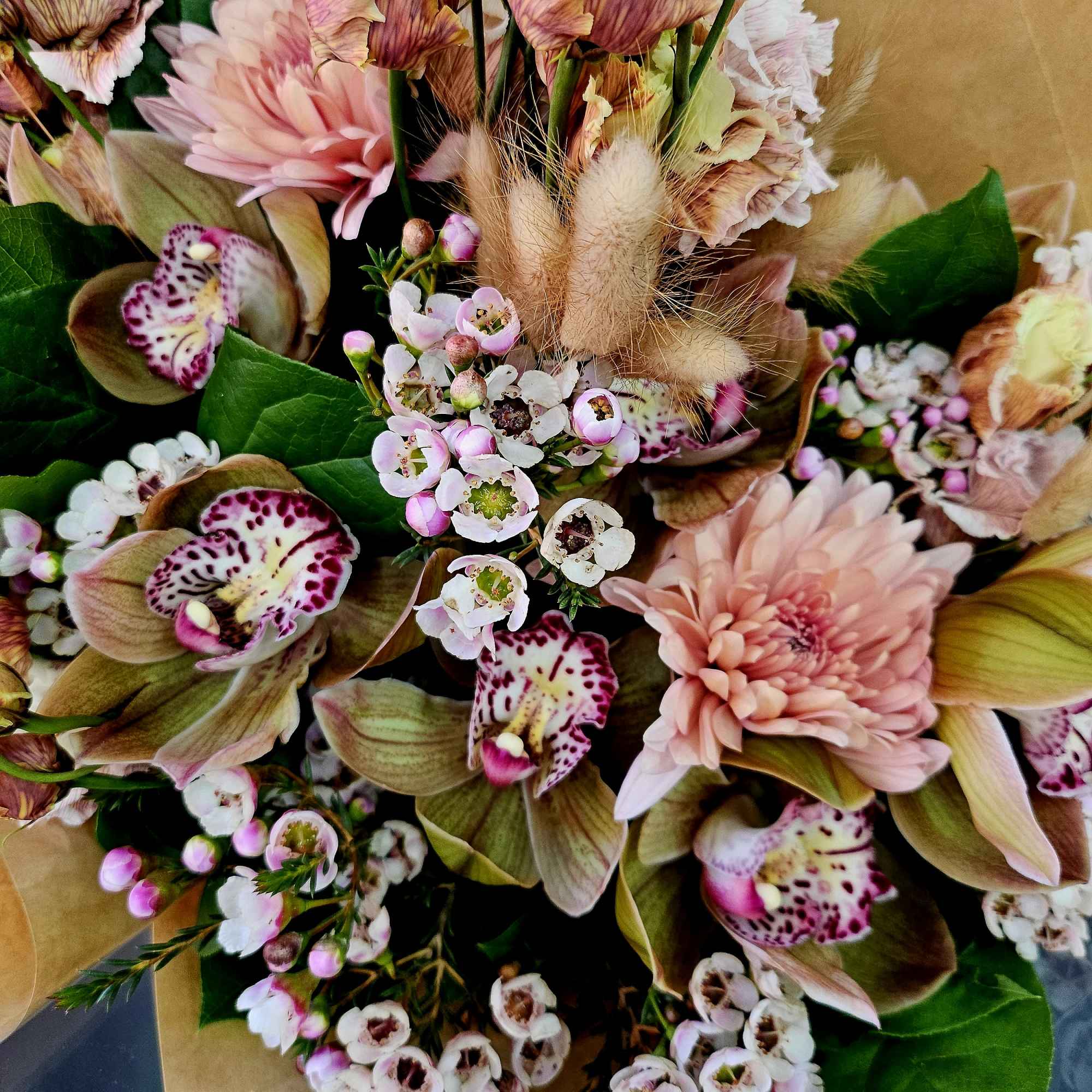 Bouquet of pink blooms with spotted orchids and small white flowers