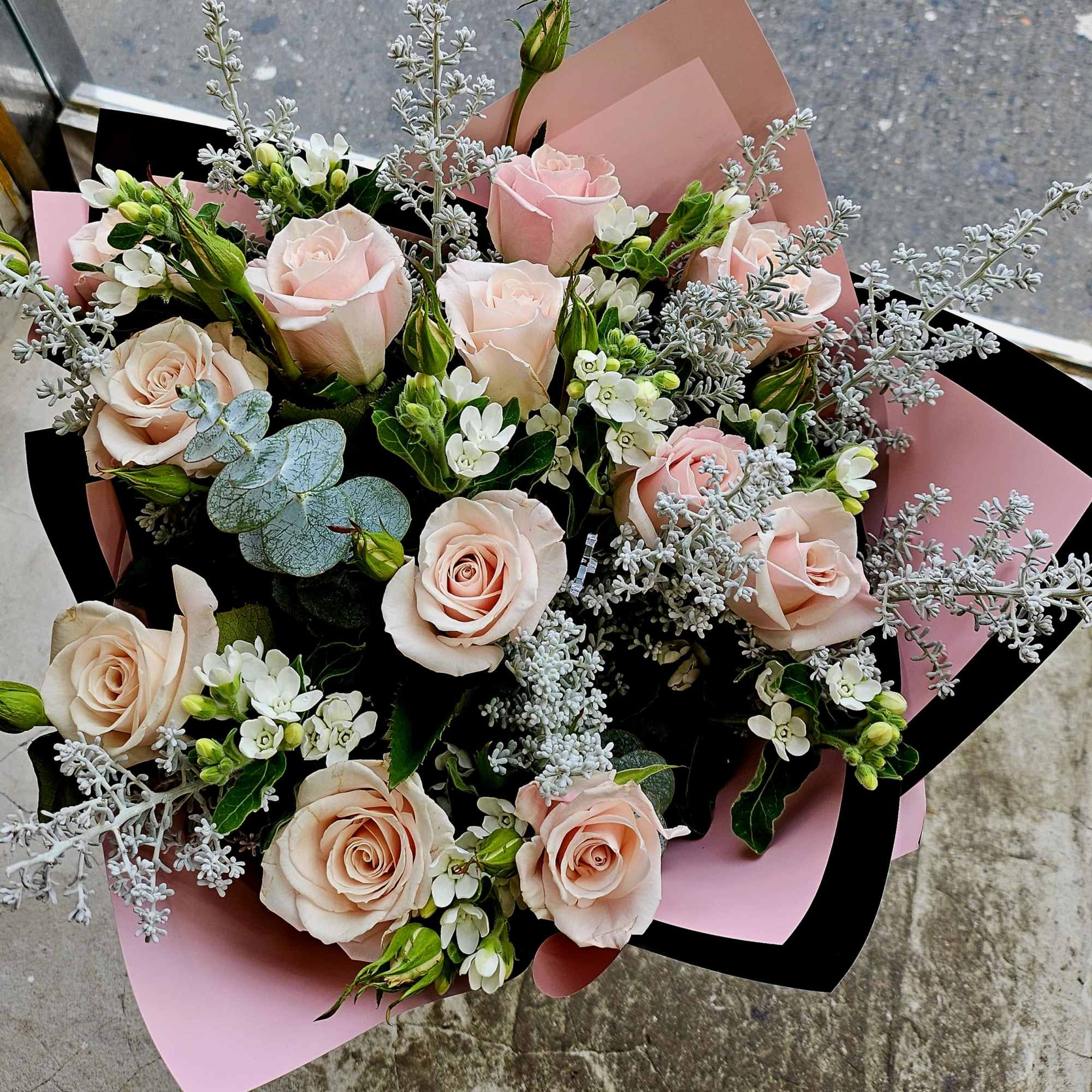 Bouquet of pale pink roses with white filler flowers and silver foliage
