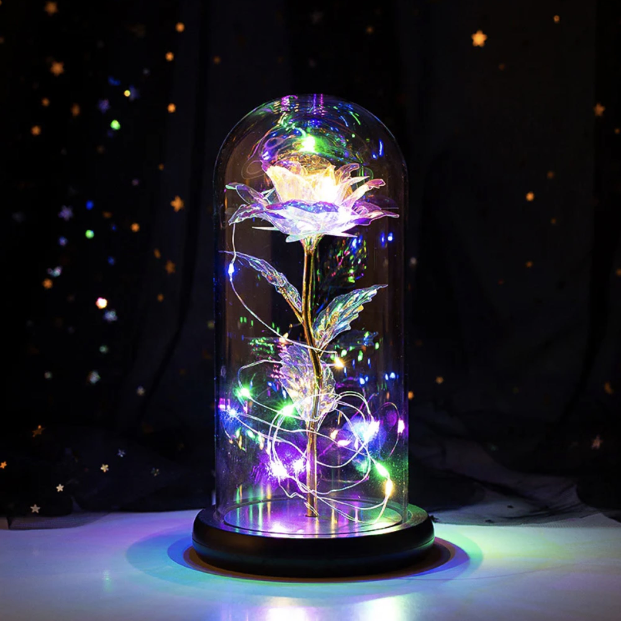 Glowing artificial flower under a glass dome with multicolor lights