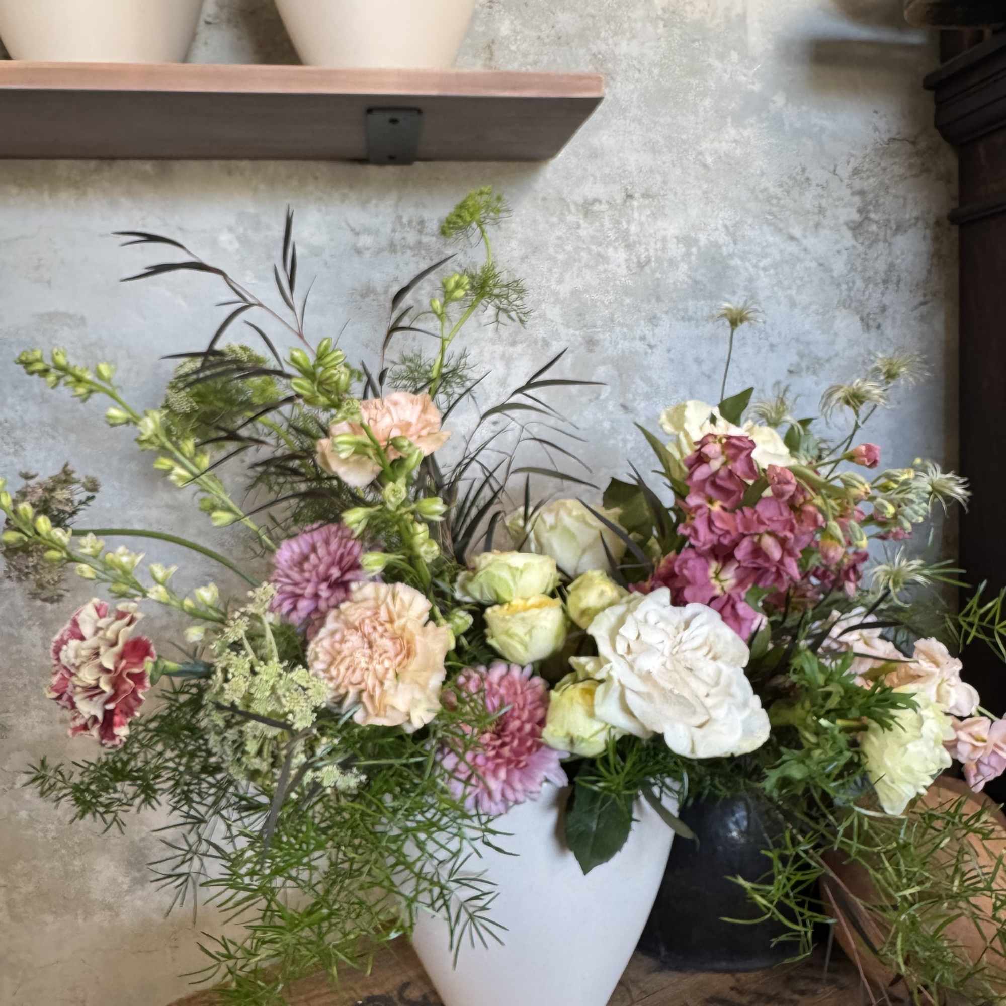 Mixed pink and white floral arrangement in a white vase