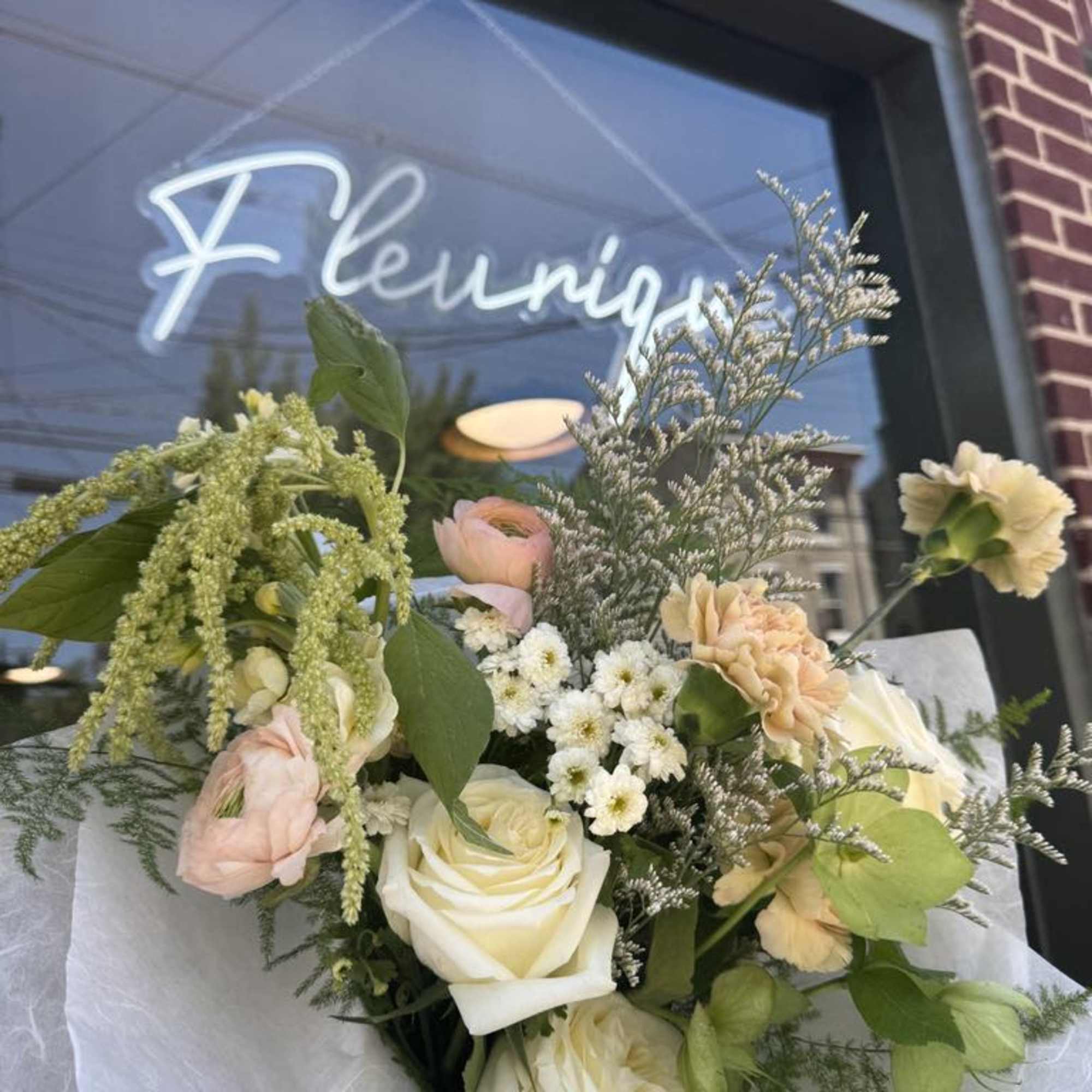 Bouquet of white and blush flowers wrapped in white paper