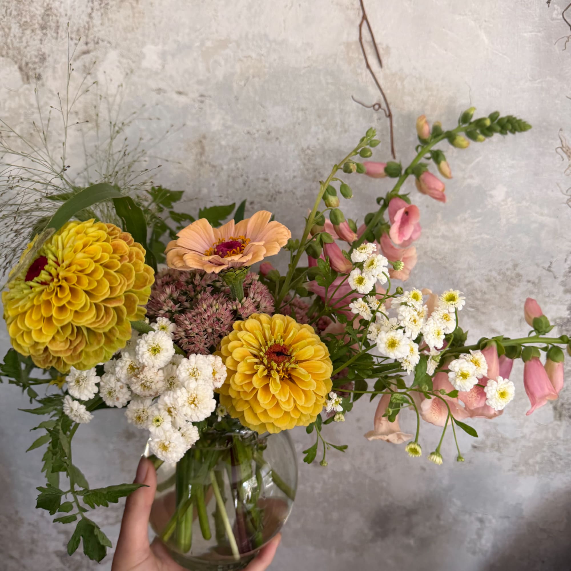 Mixed bouquet in a clear glass vase with yellow and pink blooms
