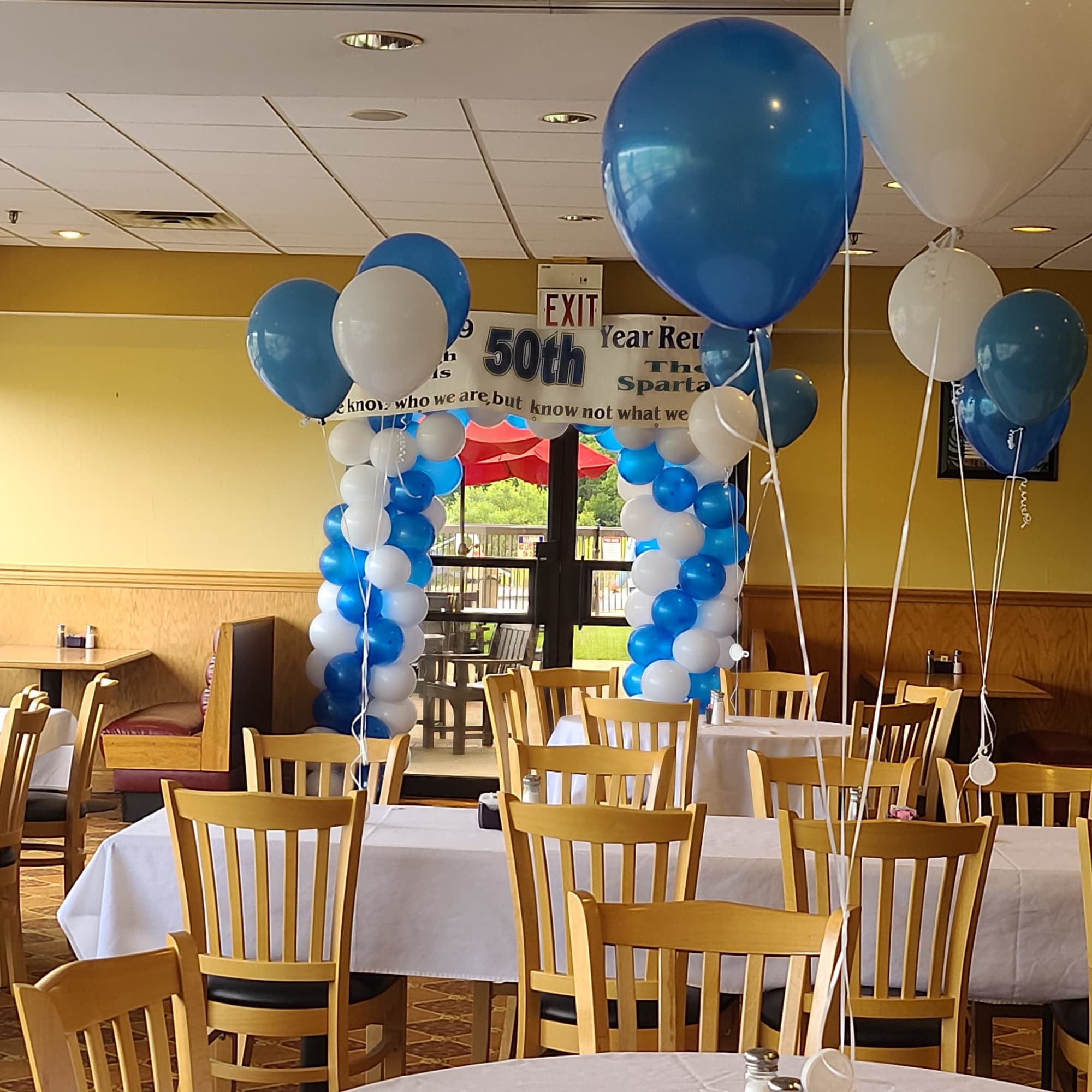 Blue and white balloons decorate a restaurant dining area.
