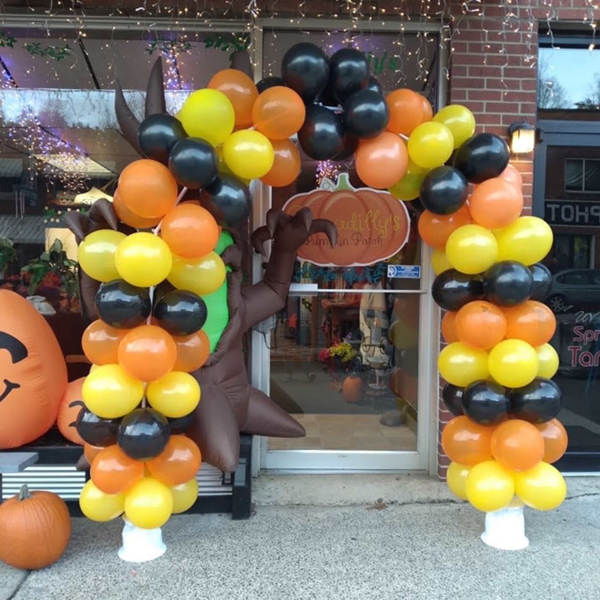 Halloween balloon arch in black, orange, and yellow with pumpkin accents