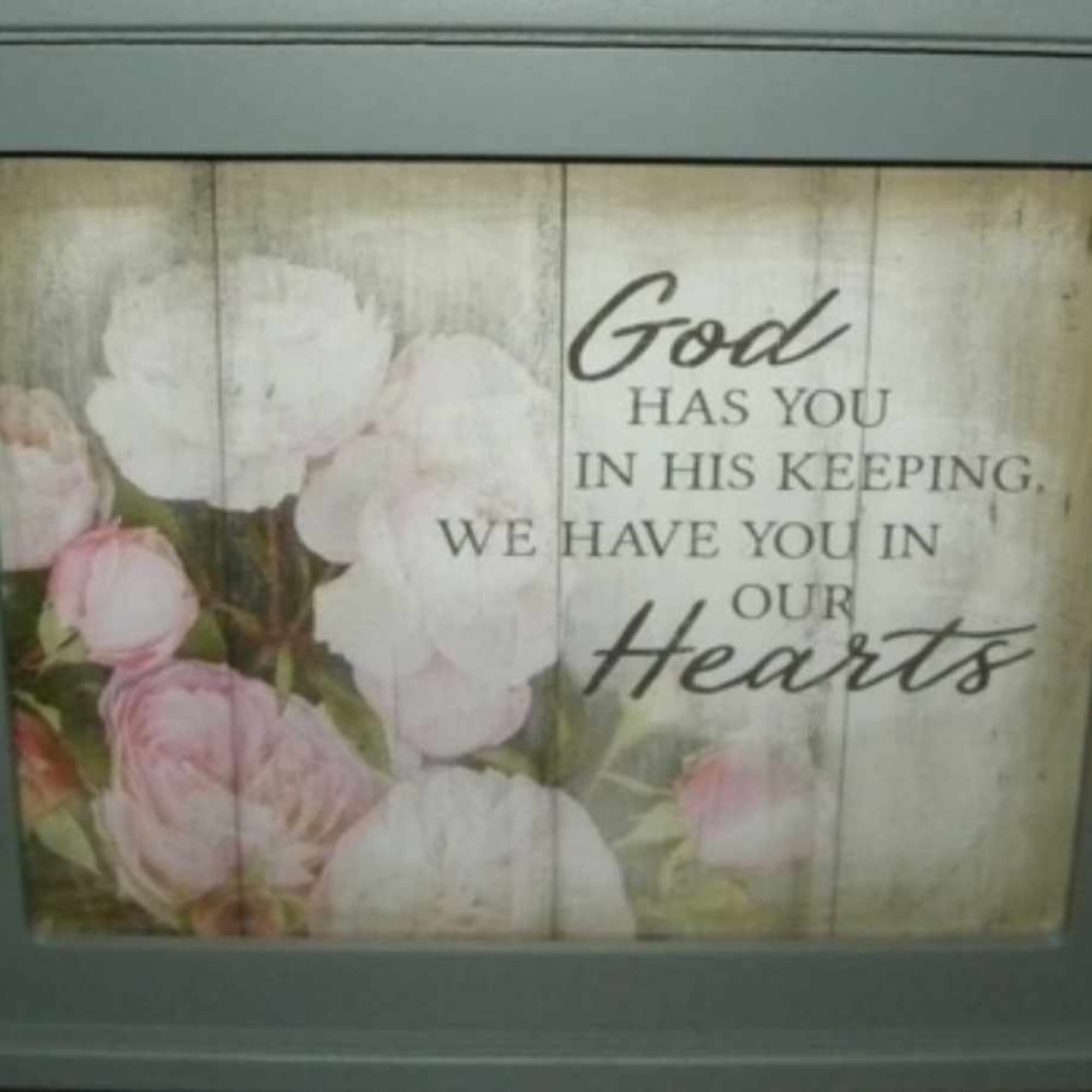 Framed floral sign with pink and white roses and a sympathy message