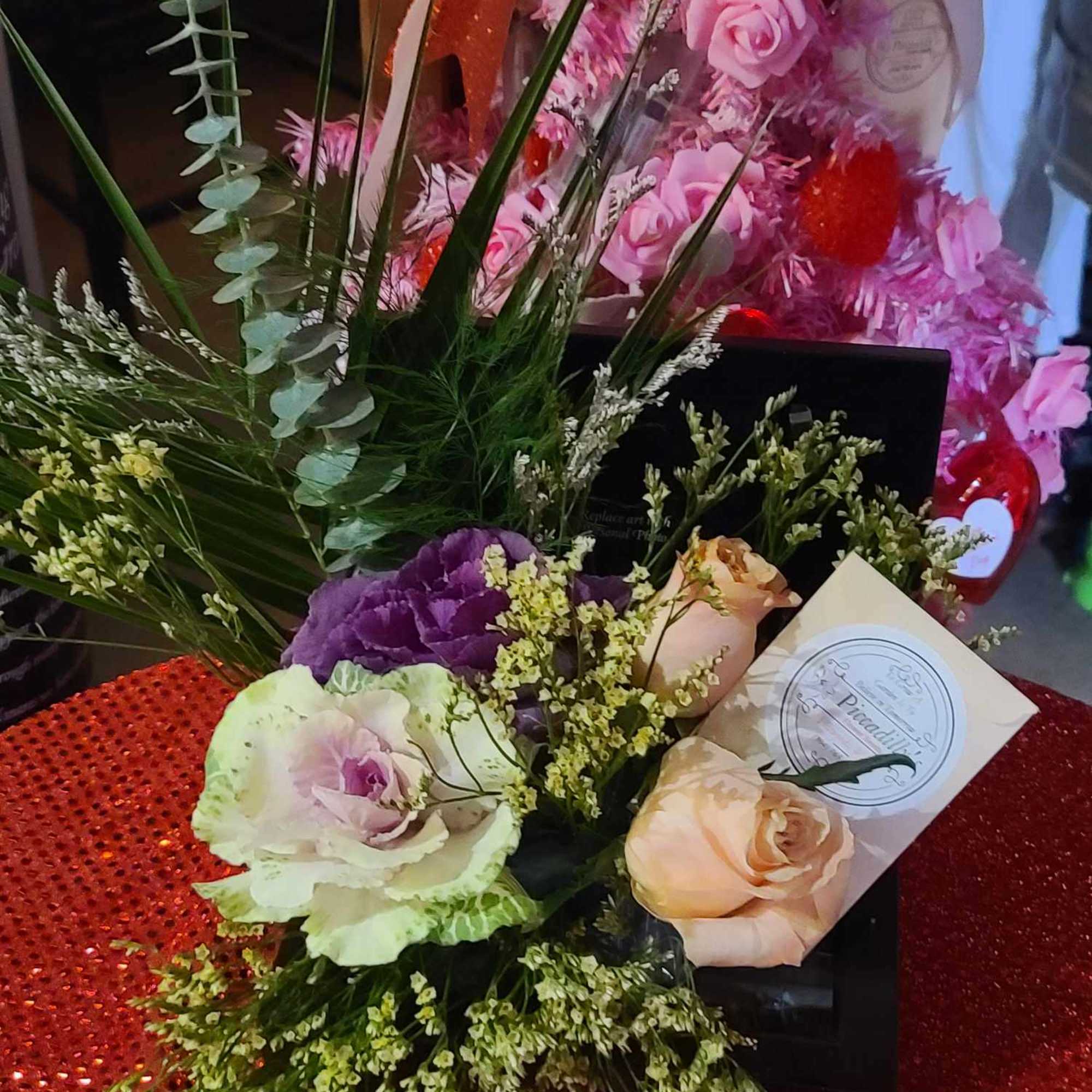 Mixed bouquet with pink and peach roses and purple blooms in a gift box