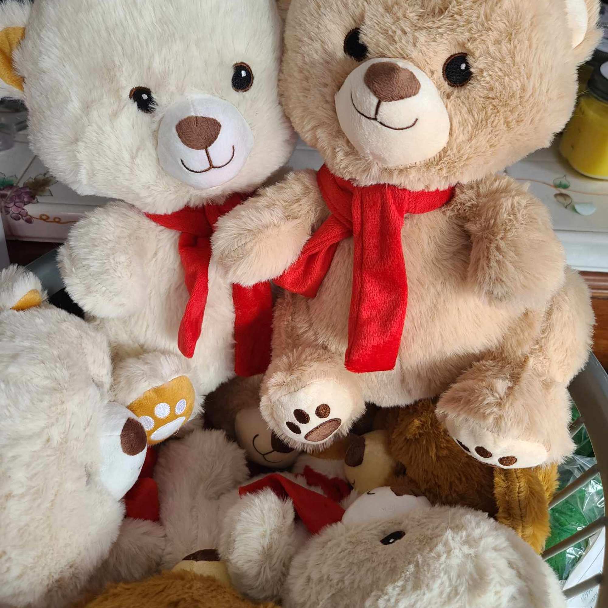 Plush teddy bears with red scarves stacked together