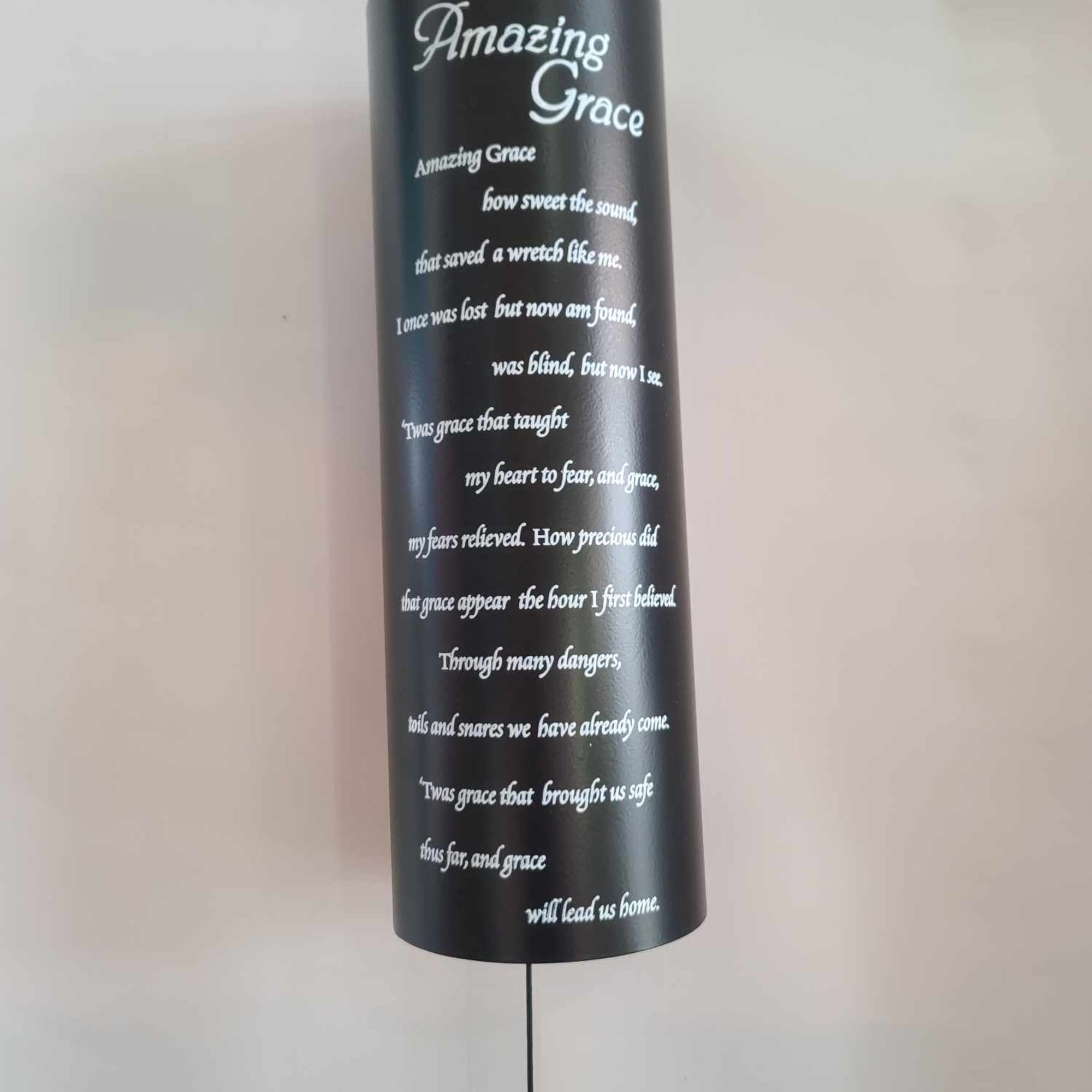 Black hanging memorial plaque with white "Amazing Grace" text
