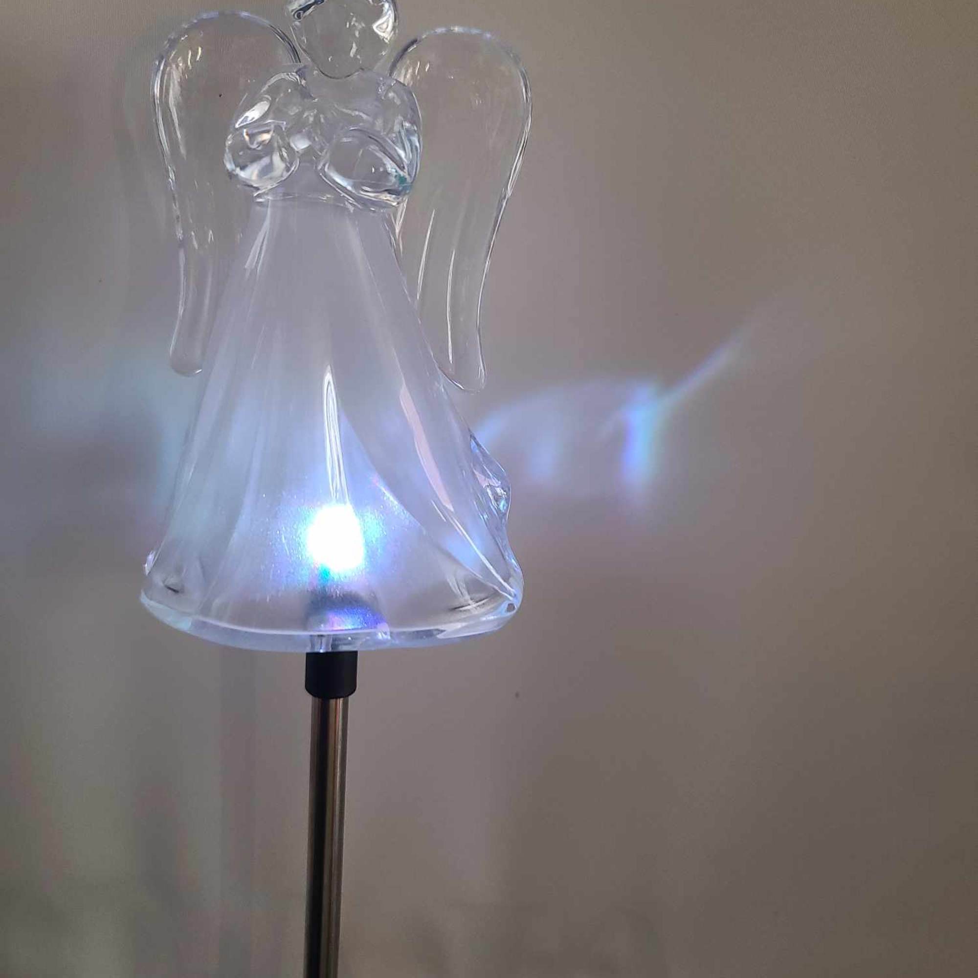 Clear glass angel figurine on a metal stand