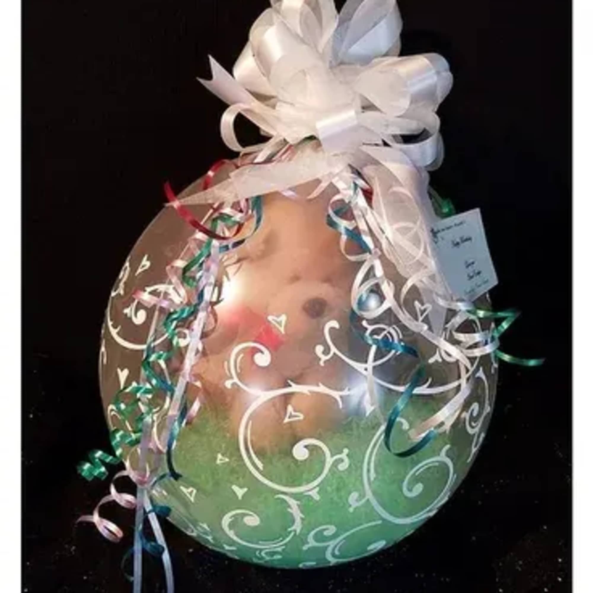 Clear balloon gift with white bow and curled ribbons